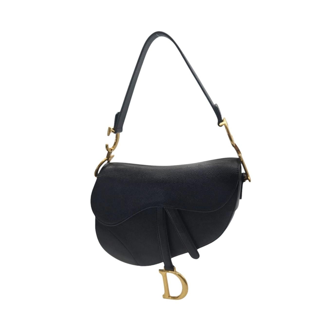 Questa elegante borsa Christian Dior è realizzata in pelle di vitello granulata di colore nero con finiture dorate e trasuda eleganza. L'interno spazioso e la tasca posteriore offrono praticità, mentre l'aggiunta della tracolla in cotone ricamato in