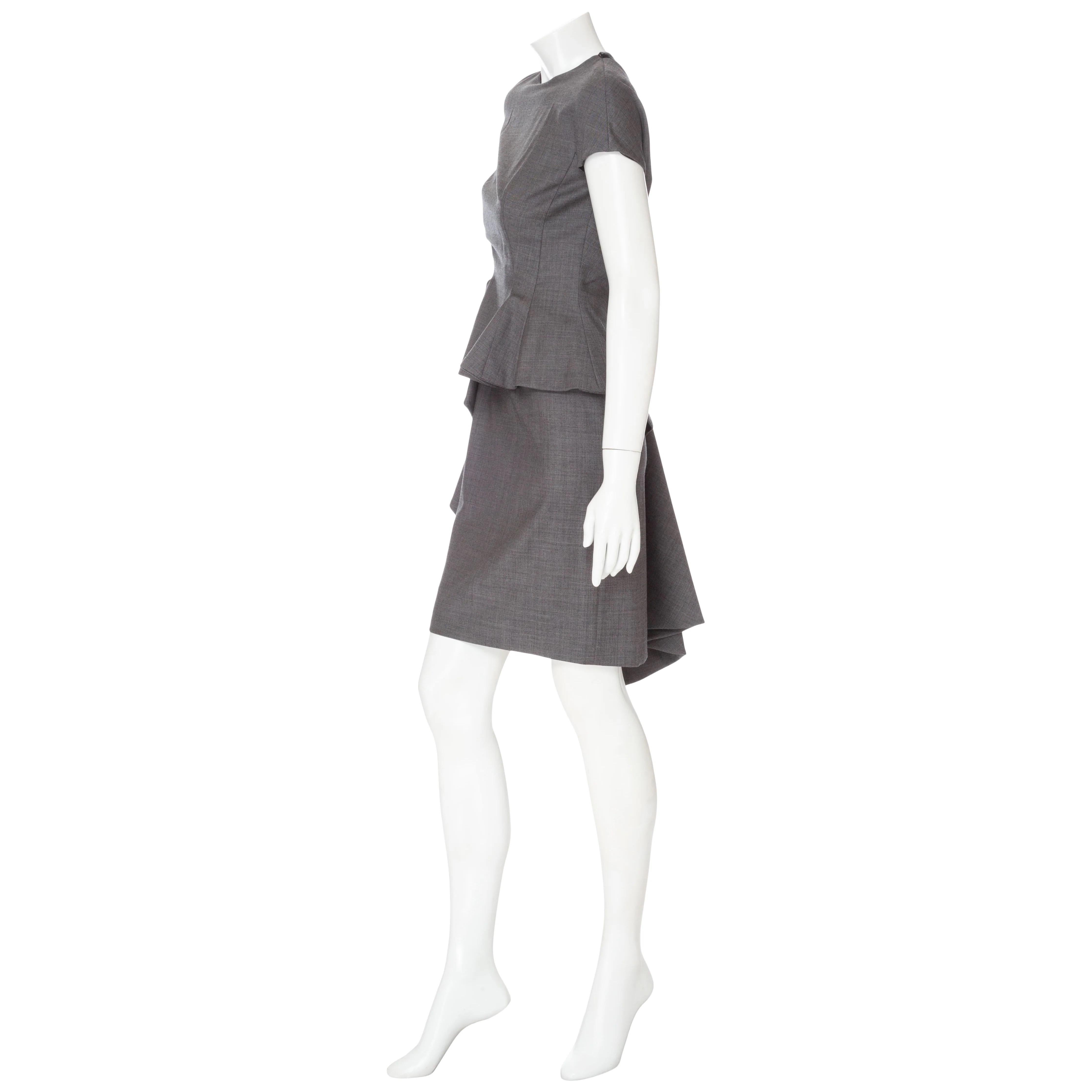 Christian Dior Gray Lightweight Wool Avant Garde Peplum Dress 

Gray/Grey
Round neckline
Short sleeves
Peplum front
Side ruffle detail
Pleated back detail
Back shoulder cutout
Back zipper closure on shell and lining
Sheath silhouette
Short