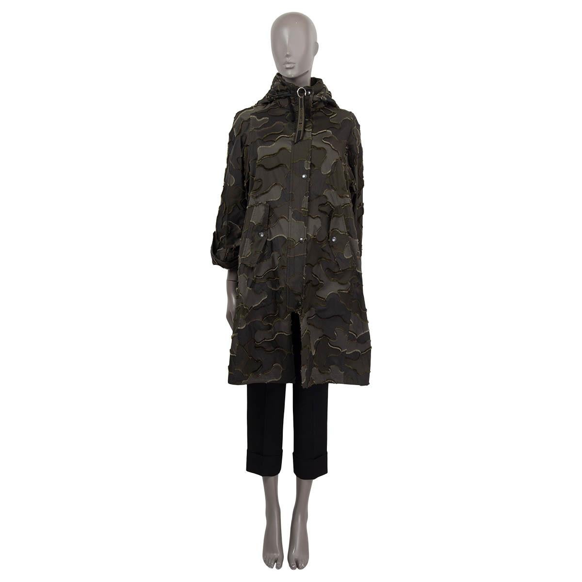 100% authentic Christian Dior camouflage oversized parka in olive green and forest polyester (100%). Features two pockets in the front with snap buttons. Opens with a black zipper and snap buttons on the front. Has been worn and is in excellent