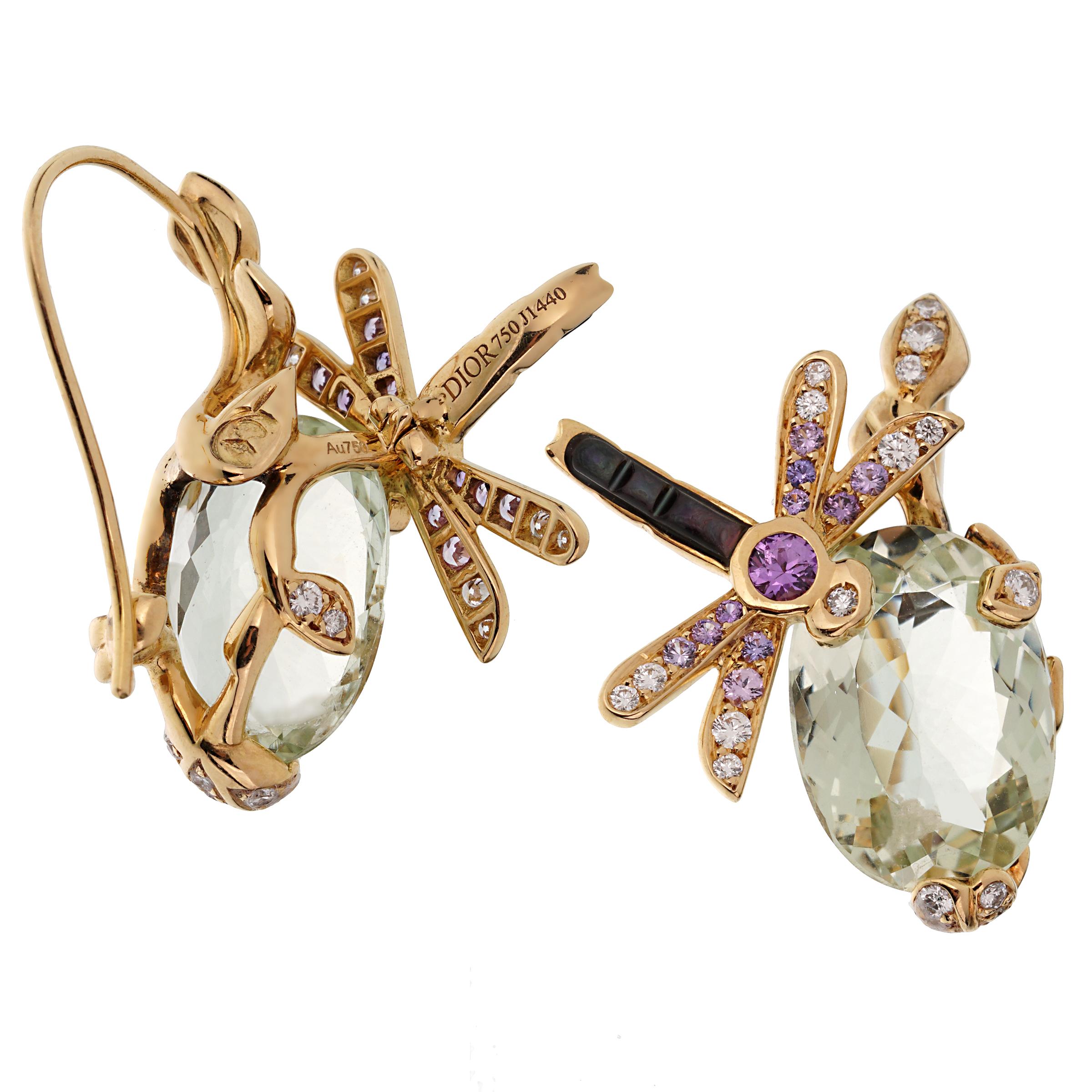 An incredible set of light and airy Christian Dior earrings showcasing a dragonfly motif set with round brilliant cut diamonds and bright beautiful multicolored sapphires atop of a oval shaped green beryl in shimmering 18k yellow gold.