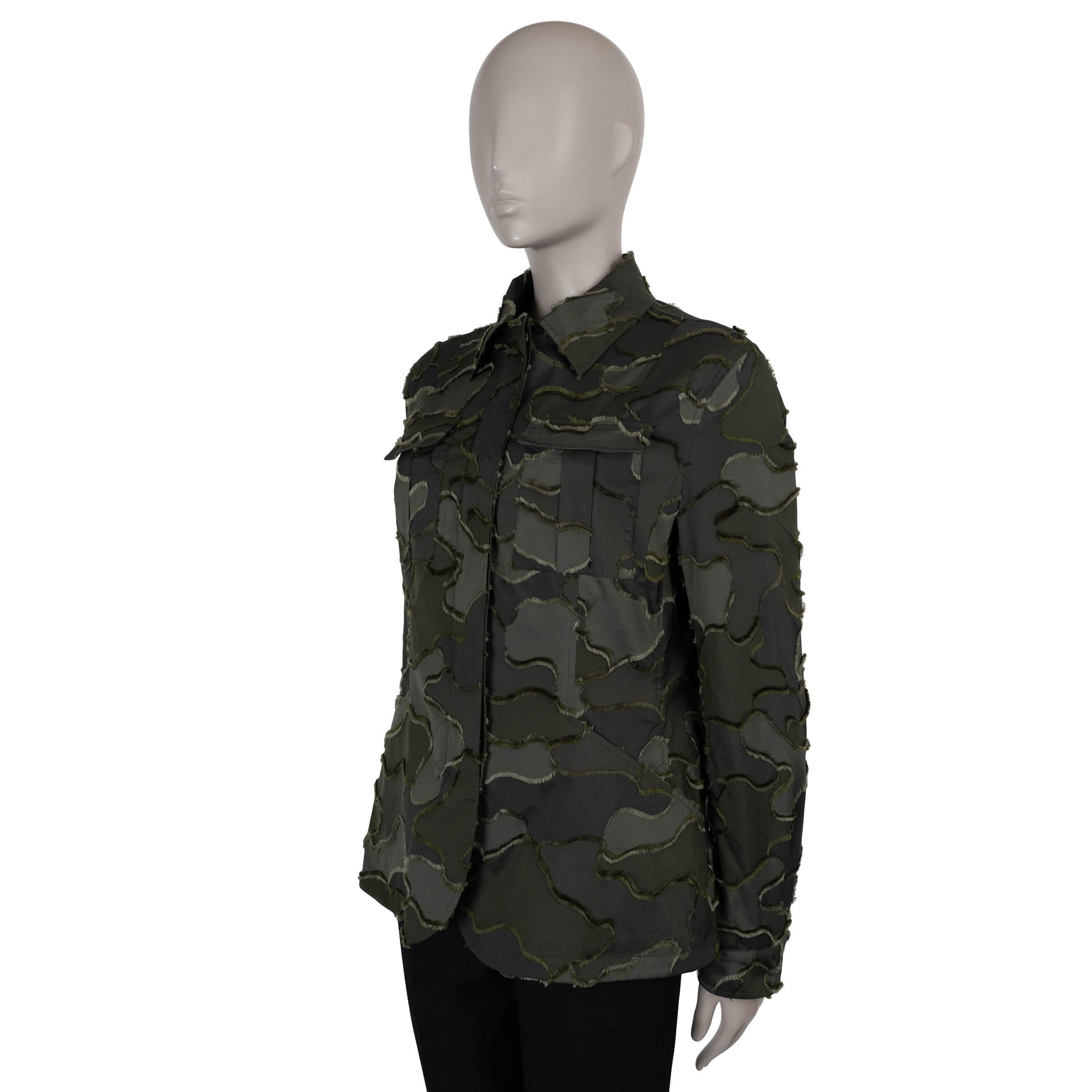 Questa giacca utilitaria 100% autentica di Christian Dior in poliestere patchwork mimetico verde militare (100%) unisce funzionalità robusta e sartoria raffinata. Progettato con una silhouette aderente, presenta un colletto a punta strutturato, due