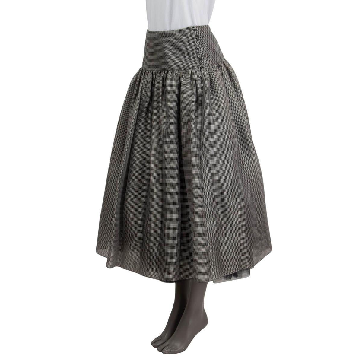100% authentic Christian Dior midi skirt in black and silver small checks silk gauze (100%). Features a wide waistband. Closes with buttons on the side. Comes with separate under-skirt in black polyamide (100%) with a zip closure. Has been worn and