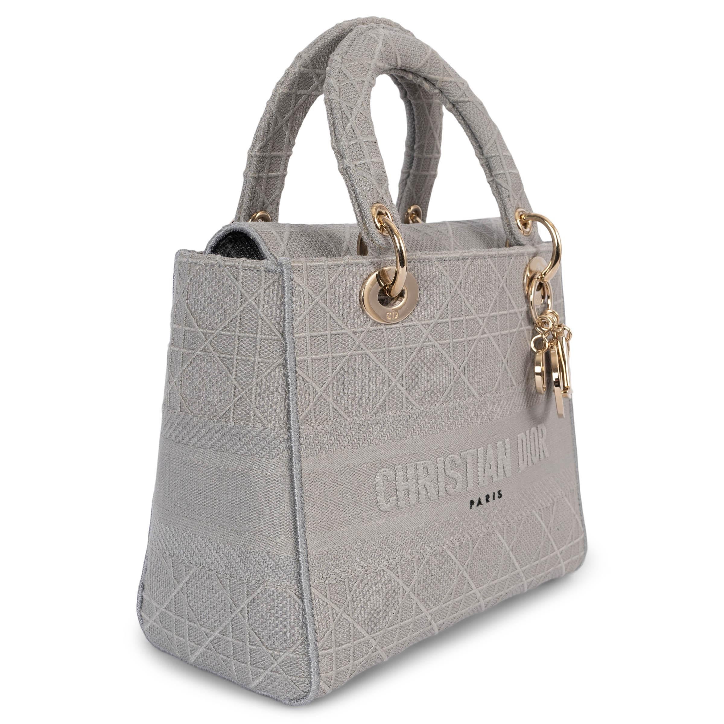 100% authentic Christian Dior Medium Lady D-Lite tote in grey cannage embroidered canvas featuring light gold-tone hardware. The interior is lined in a grey canvas with one zipper pocket against the back and an open pocket against the front. The