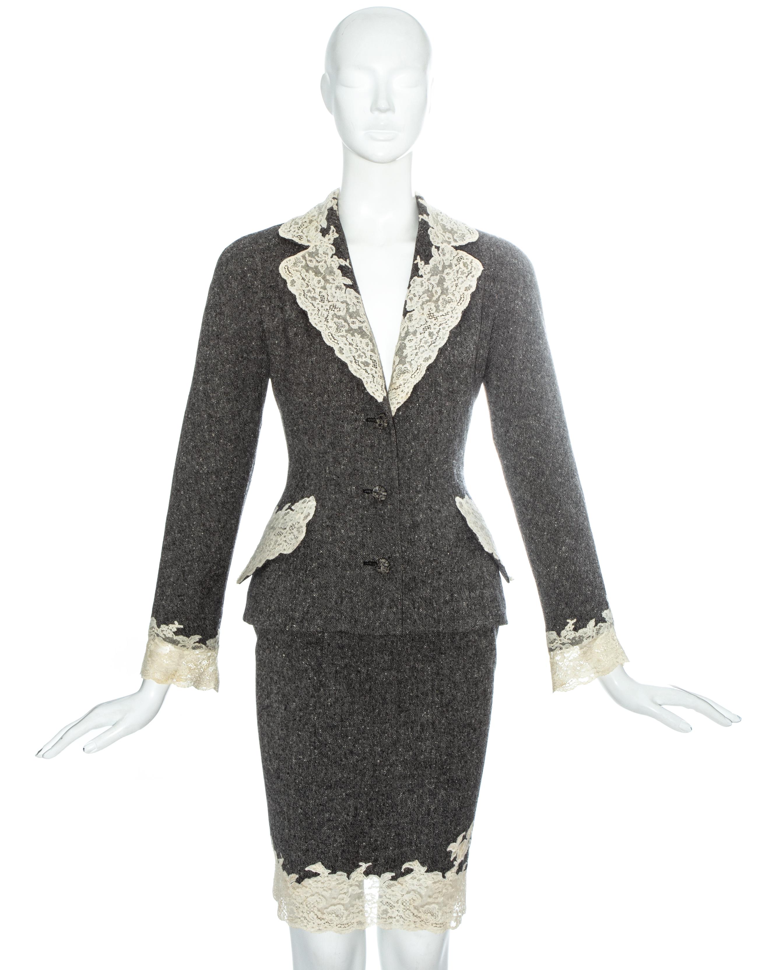 Christian Dior by John Galliano. Grey Donegal tweed skirt suit edged in white Calais lace. 

Fitted blazer jacket with fabric button closures, two front flap pockets, internal padding on the hips and ivory silk lining with embroidered 'CD'. Sold