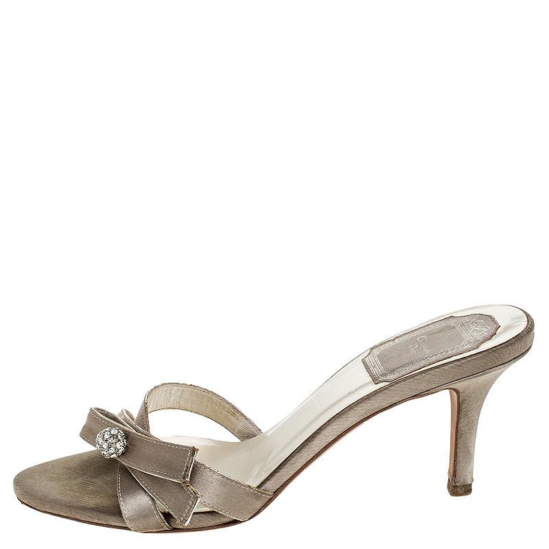 Comfort and style come together with these mules from Christian Dior! The grey sandals are crafted from satin and feature an open toe silhouette. They flaunt crystal balls embellished on the upper straps and are sure to make your feet very