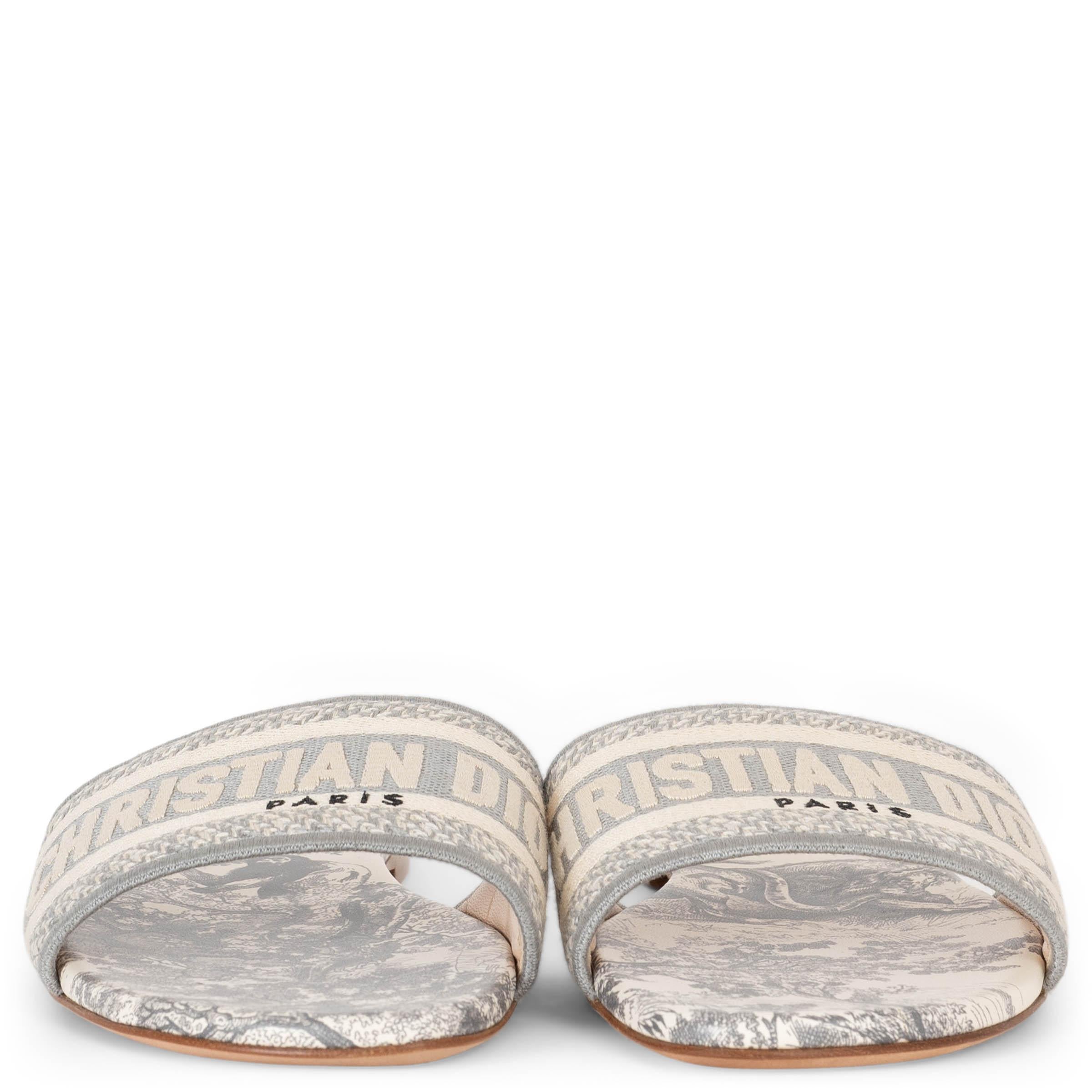 These 100% authentic Christian Dior Dway Toile de Jouy slides in grey are crafted from embroidered cotton canvas. They feature a logo-embroidered wide strap and leather insoles, offering a chic, relaxed look with a vibrant touch. Perfect for adding