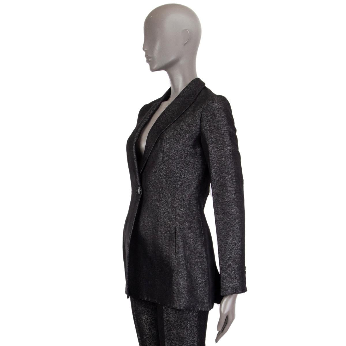 Christian Dior fitted blazer in metallic black and grey viscose (84%) and silk (16%). Closes with one button at front and is lined in black silk (100%). Two slits on the back. Has been worn once and is in virtually new condition. Comes with matching