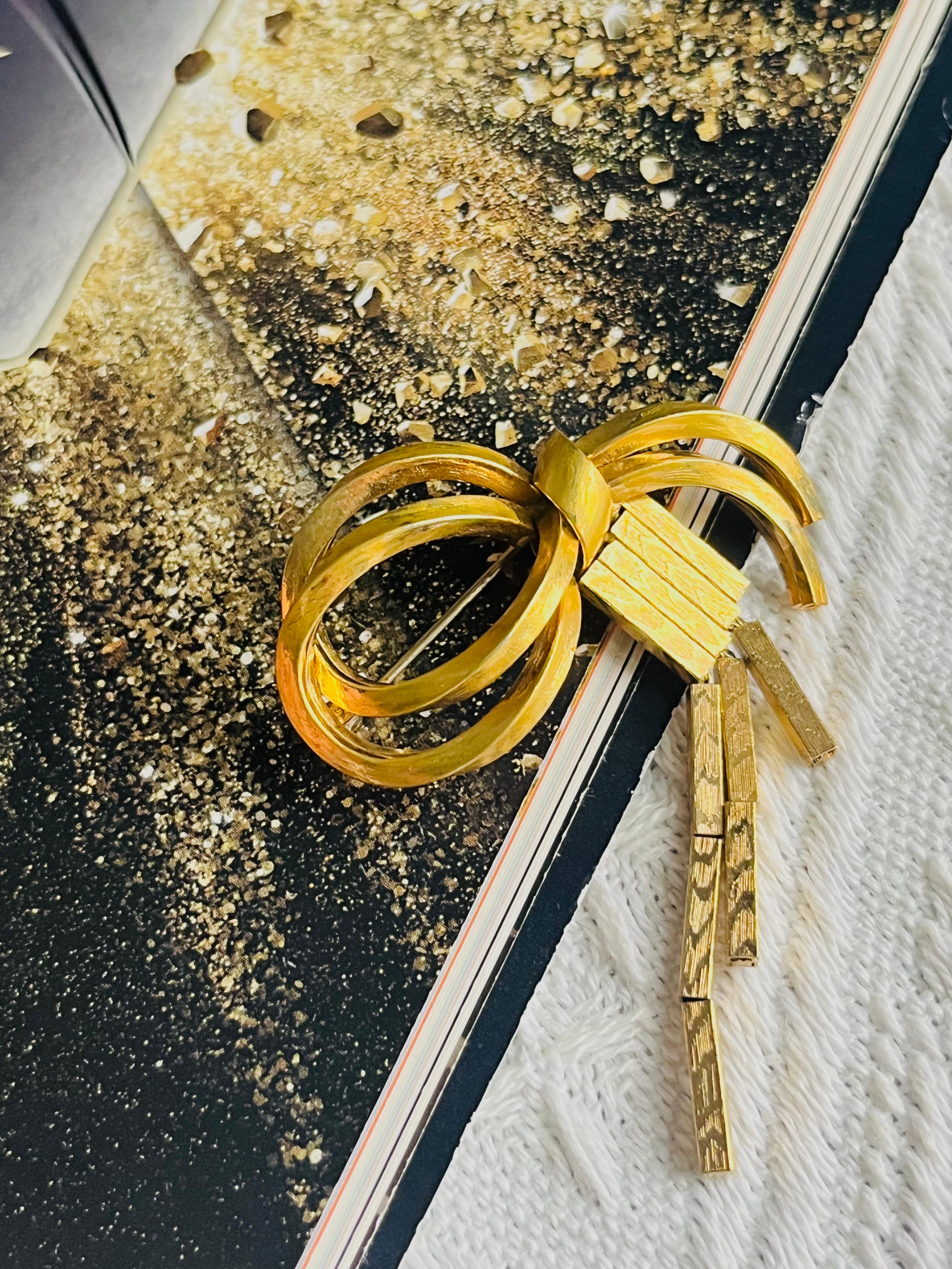 Christian Dior GROSSE 1958 Vintage Unisex Geometric Double Knot Bow Ribbon Butterfly Trio Bar Tassel Modernist Brooch, Gold Tone

Very good condition. Some light scratches and colour loss at side and back. 100% Genuine.

A unique piece. This gold