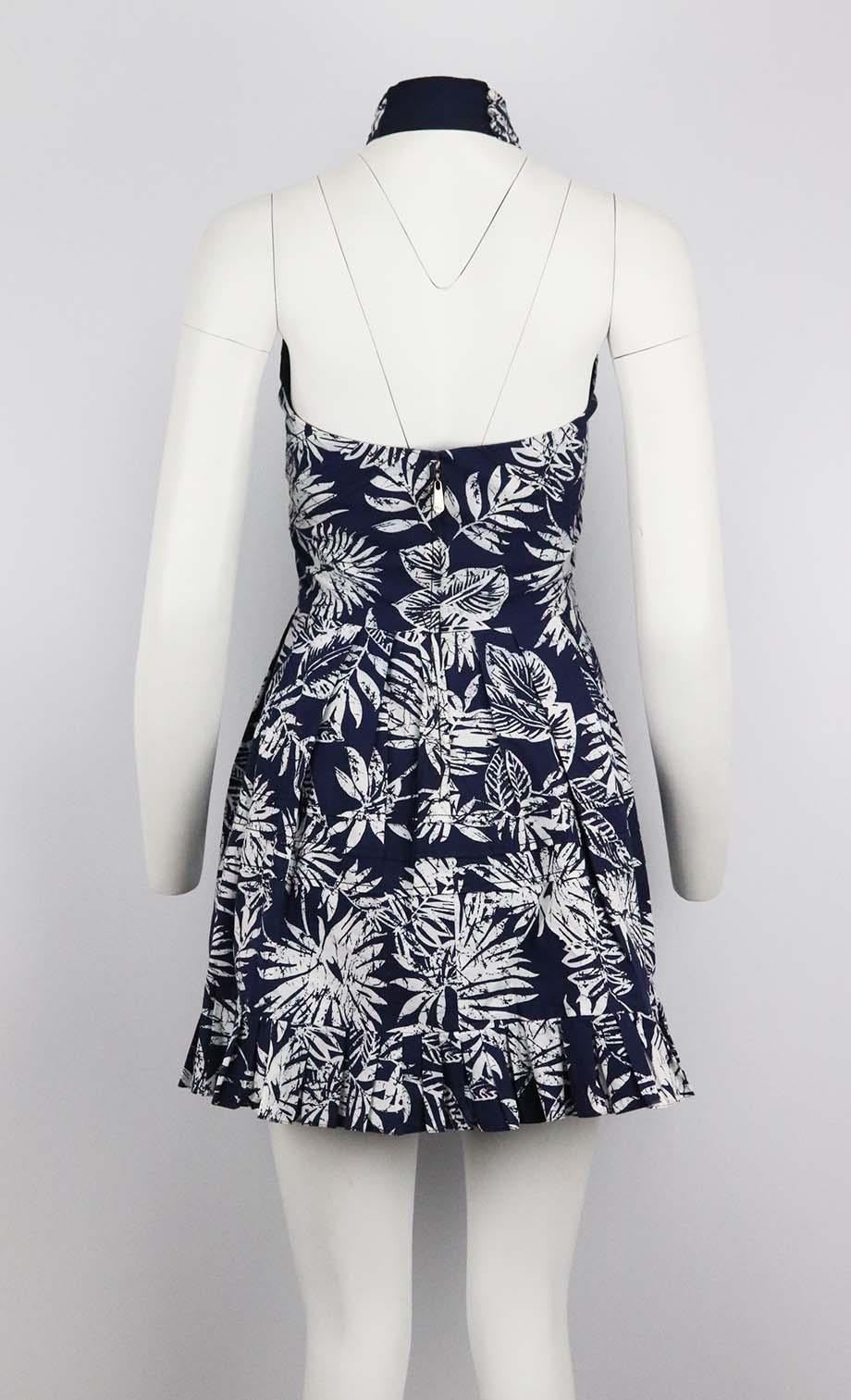 This mini dress by Christian Dior is made from a Hawaiian-print that ties at the back for a halterneck silhouette, the light cotton fabric is perfect for sun-soaked beach strolls or hot city days. Navy and ecru cotton. Zip fastening at back. 100%
