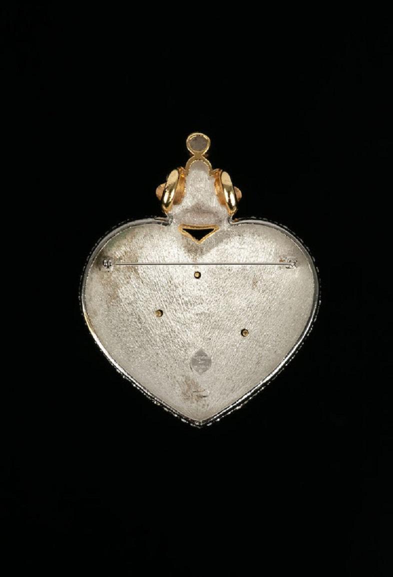 Dior - (Made in Germany) Brooch representing a heart in silver and gold metal paved with rhinestones.
Collection Prêt-à-porter Automne-Hiver 1992

Additional information:
Dimensions: 9.5 cm x 7.5 cm
Condition: Very good condition
Seller Ref number: