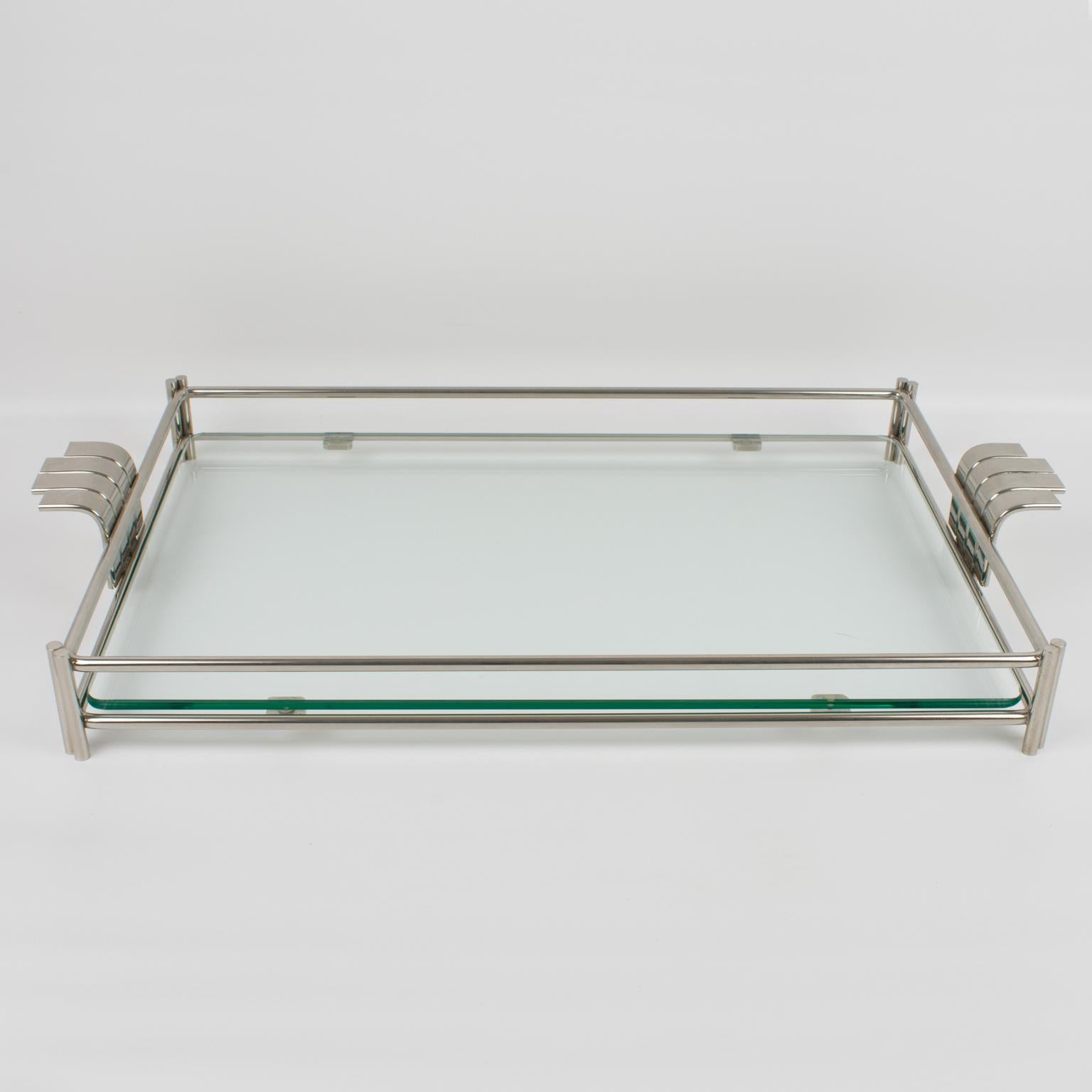 This sophisticated modernist barware serving tray platter was designed for the Christian Dior Home Collection in the 1980s. The large rectangular butler shape is built with silvered metal framing and a thick glass slab insert. The tray is