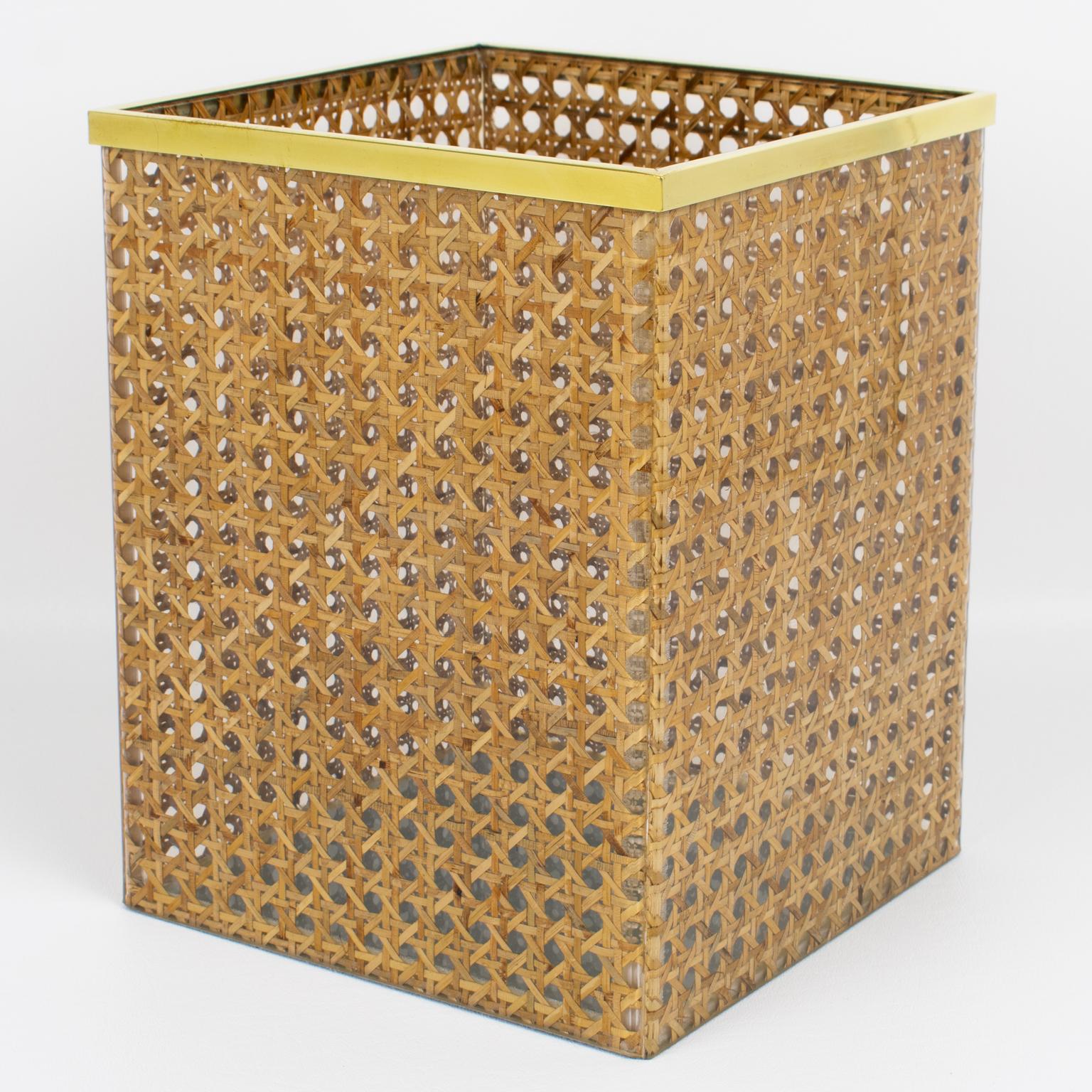 Cette jolie corbeille à papier a été conçue pour la Collection S/One de Christian Dior vers 1960. La forme géométrique est ornée d'une galerie en laiton doré et de rotin ou d'osier véritable incrusté dans la Lucite cristalline. Il s'agit d'un