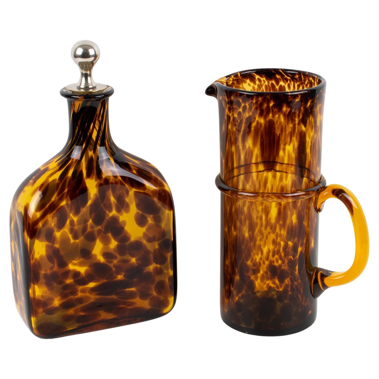 Questo set da cocktail è un elegante accessorio da bar creato da Empoli, Italia, per la Collection'S di Christian Dior Home nel 1960 circa. Una caraffa alta per Martini o limonata e un decanter geometrico con tappo compongono questa divertente