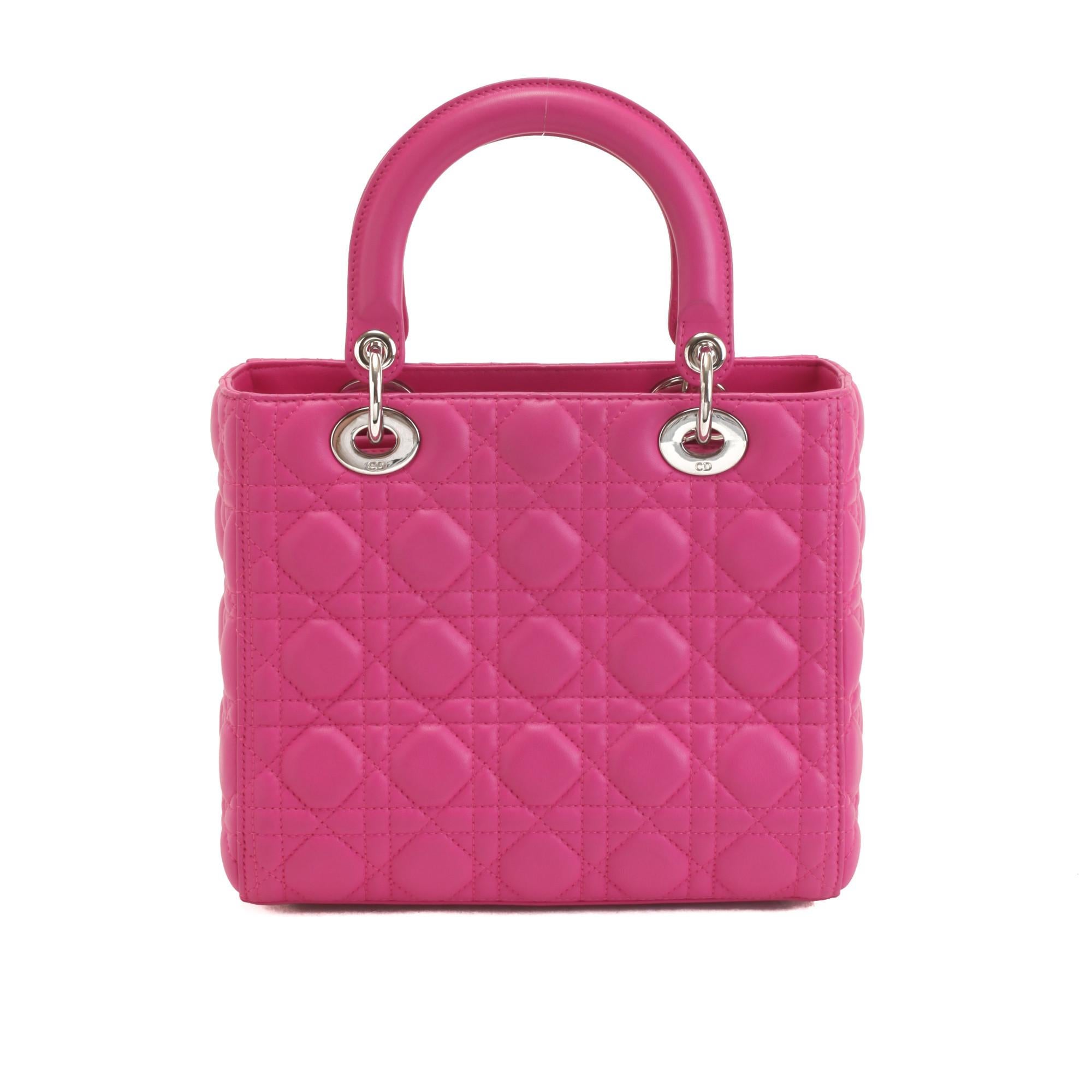 Hot pink quilted Cannage leather Christian Dior Lady Dior 2Way bag with silver-tone hardware, two flat top handles, a DIOR bag charm, a removable shoulder strap and a zip top closure. The interior is crafted in black Cannage jacquard lining with one
