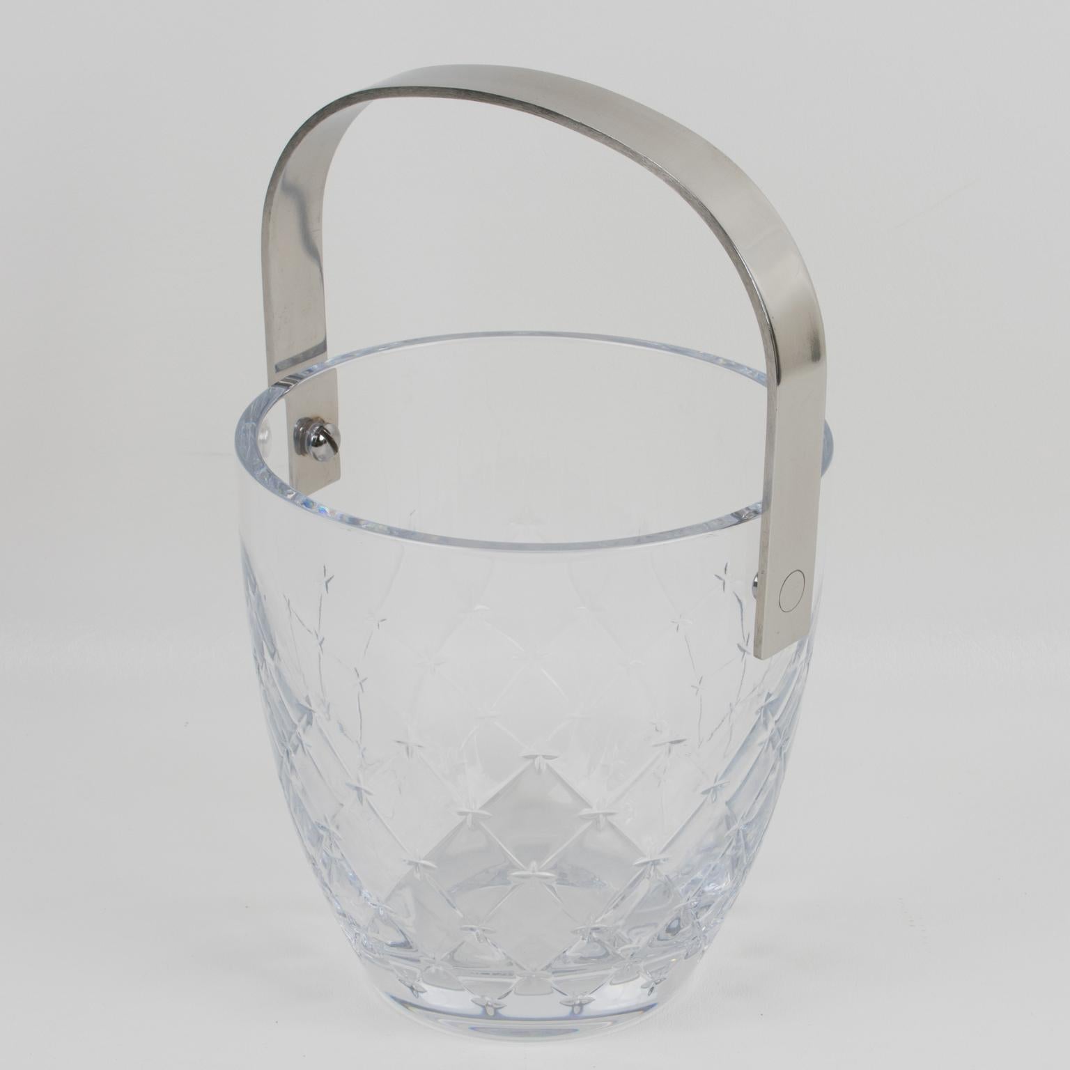 This elegant modernist ice bucket or wine cooler was designed for Christian Dior Home Collection in the 1990s. This sophisticated clear crystal ice bucket features an iconic fabric-like etched design with a tall high gloss stainless steel handle.