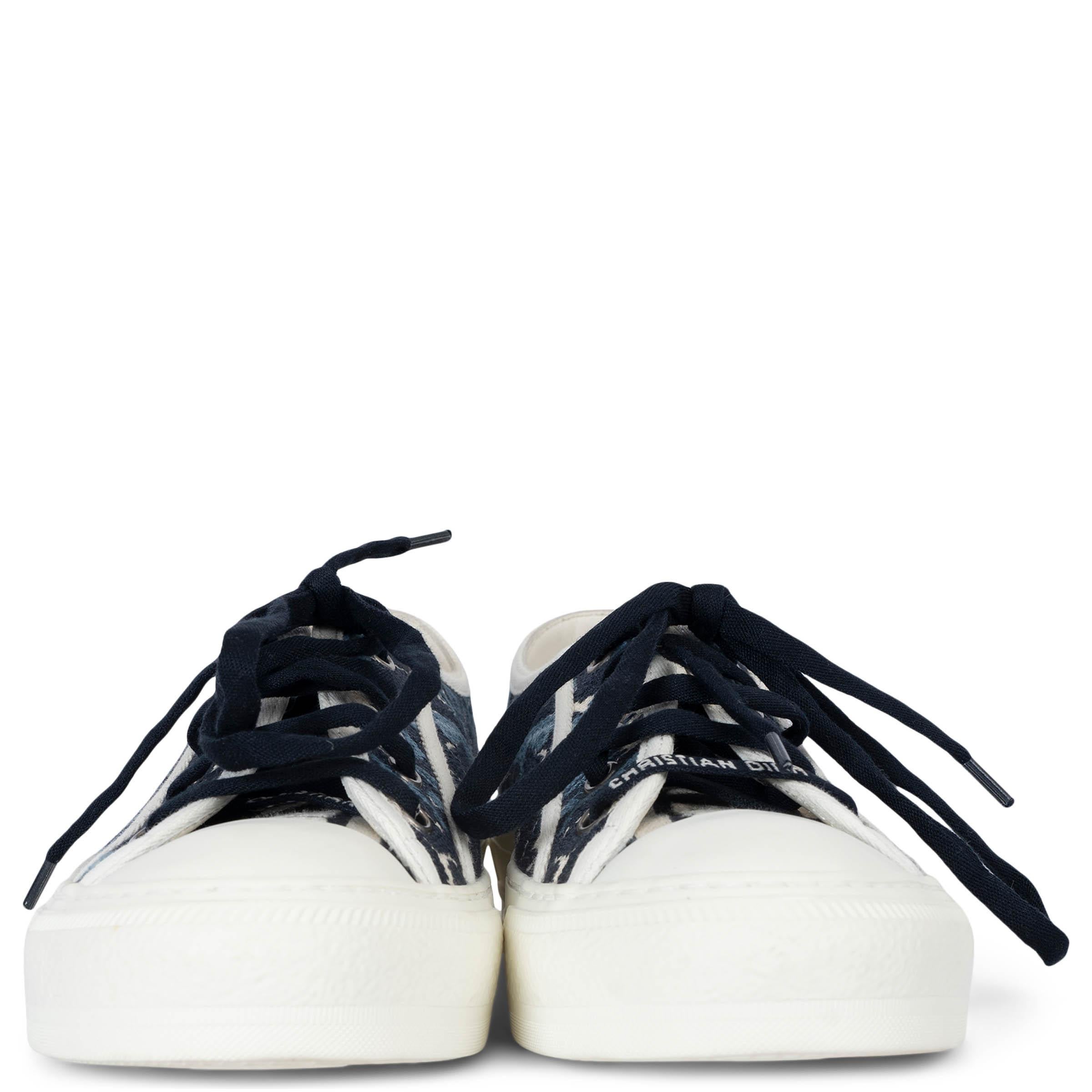 These 100% authentic Christian Dior Walk'n'Dior sneakers are crafted from indigo blue and ecru palm embroidered canvas, offering a stylish and unique design. The sneakers feature a blue and ecru embroidered tongue, Christian Dior laces, and a white