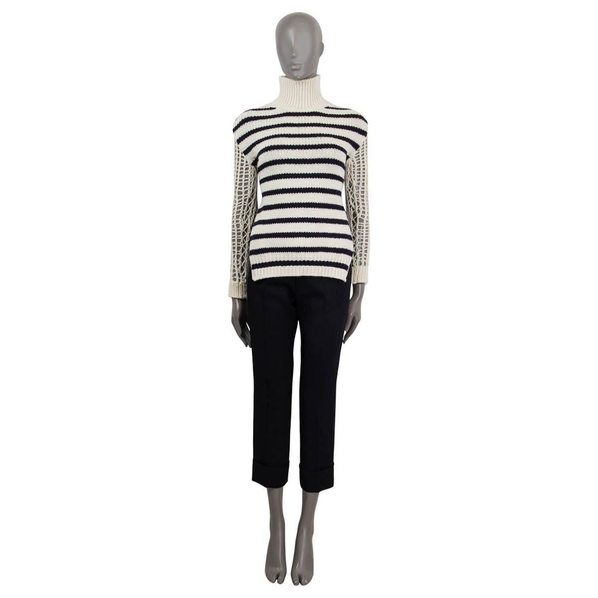 100% authentic Christian Dior Cruise 2022 open back striped turtleneck knit sweater in off-white and navy wool (70%) and polyamide (30%). Features long chunky knit sleeves and opens with a self-tie cord on the back. Unlined. Has been worn once and