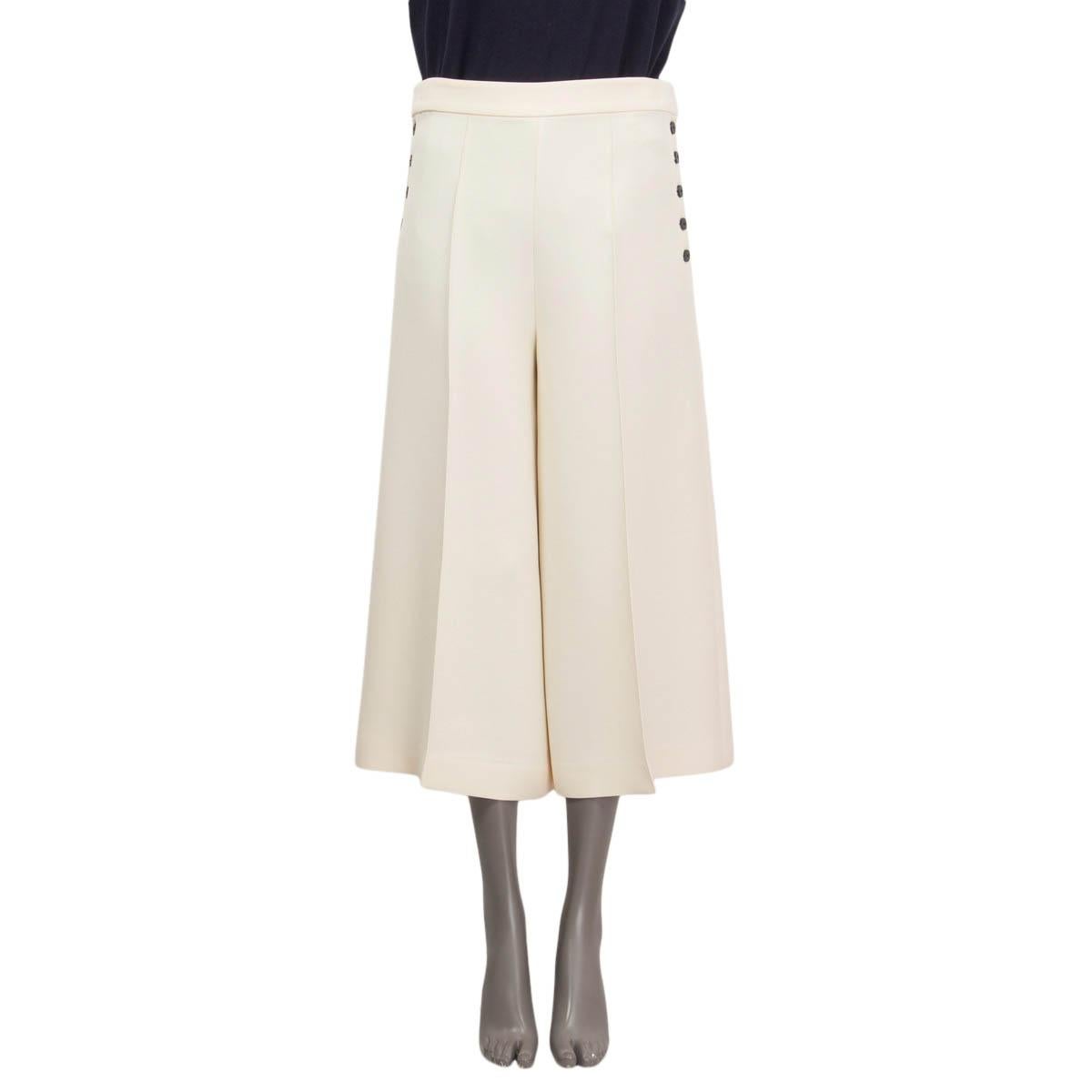100% authentic Christian Dior pleated cropped pants in off-white wool (77%) and silk (23%). Features a wide leg fit. Opens with five black buttons on both sides, concealed hooks and buttons. Unlined. Have been worn and are in excellent condition. 