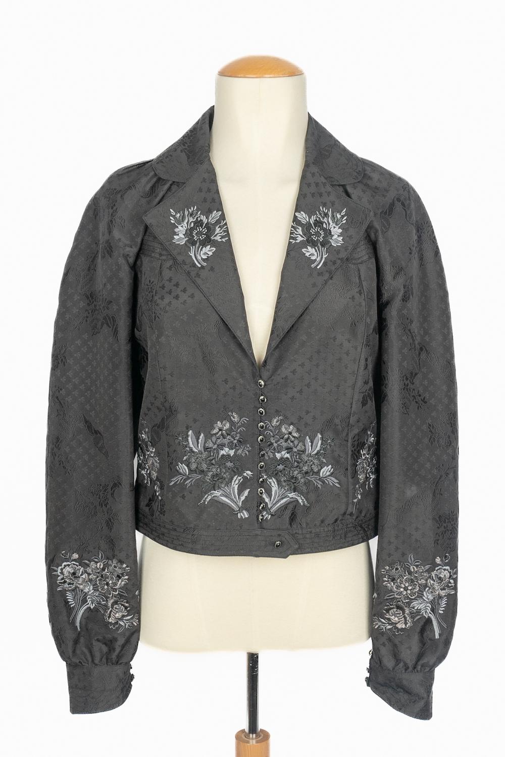 DIOR - (Made in France) Giacca corta in seta nera ricamata con un motivo floreale di colore grigio. Indicata la taglia 40FR. Una collezione del 2002 sotto la direzione artistica di John Galliano.

Condizioni:
Ottime condizioni

Dimensioni:
Larghezza