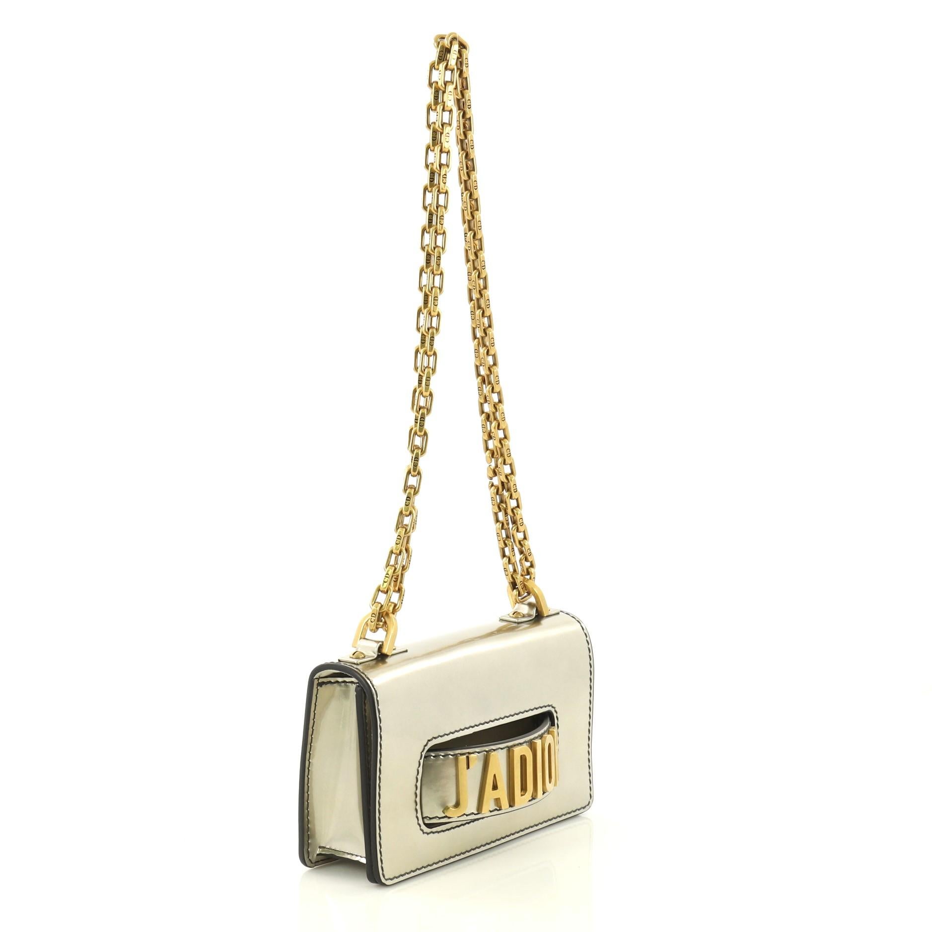This Christian Dior J'adior Flap Bag Patent Mini, crafted from gold metallic patent leather, features chain link strap, slot handclasp, and aged gold-tone hardware. Its flap opens to a beige suede interior with slip pocket. 

Estimated Retail Price:
