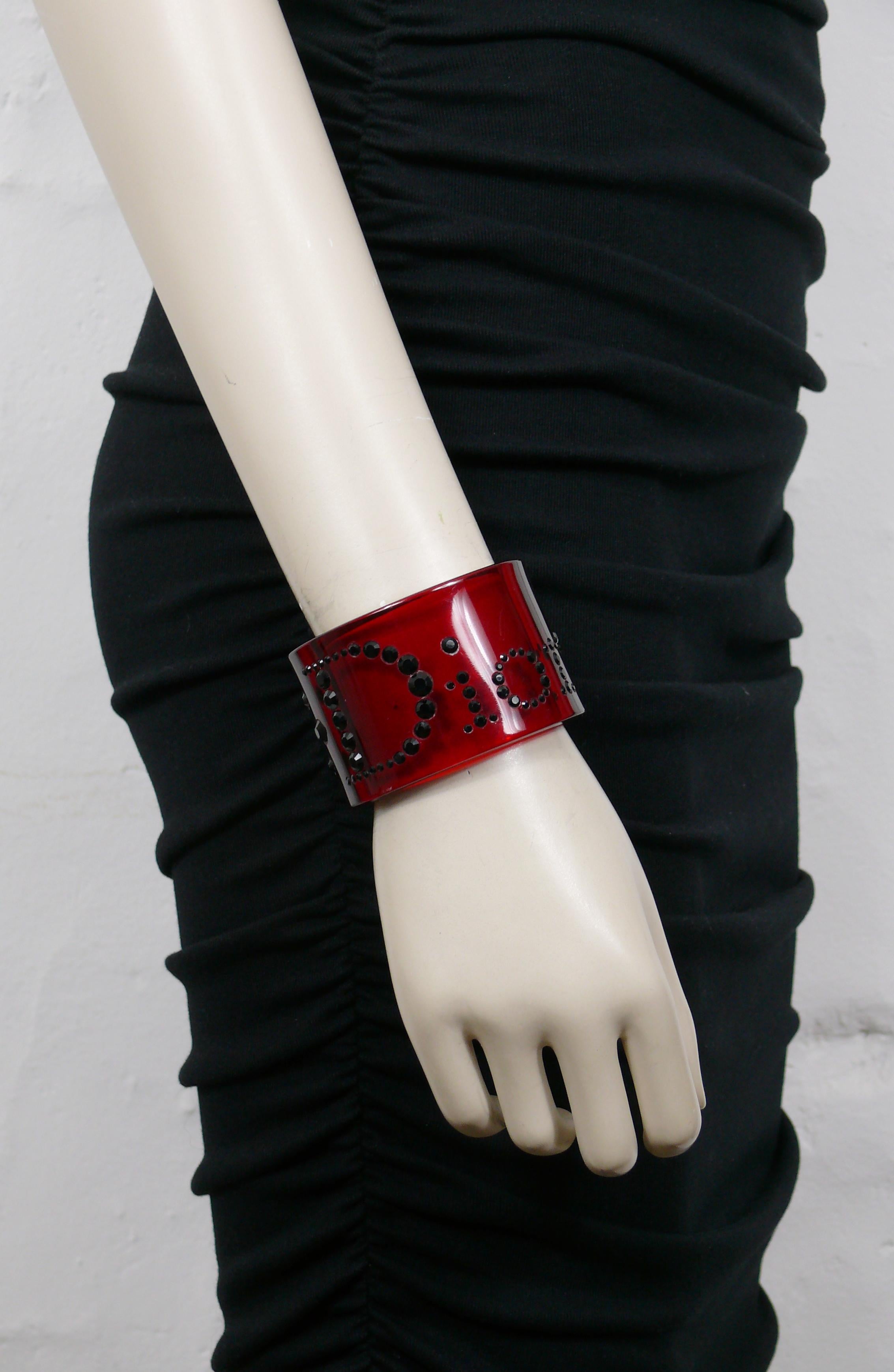 CHRISTIAN DIOR transparent red resin cuff bracelet embellished with jet black crystals forming the word DIOR.

Unmarked (usual for these models).

Indicative measurements : inner measurements approx. 5.5 cm x 4.5 cm (2.17 inches x 1.77 inches) /