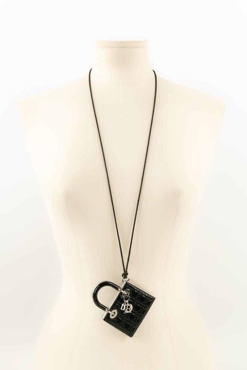 Dior - Accessoire bijoux mini sac Lady Dior en métal argenté et cuir noir. L'intérieur du bijou est composé de deux compartiments pour le maquillage.

Informations complémentaires :
Condit : Bon état
Dimensions : 9 cm x 6,5 cm : 9 cm x 6,5