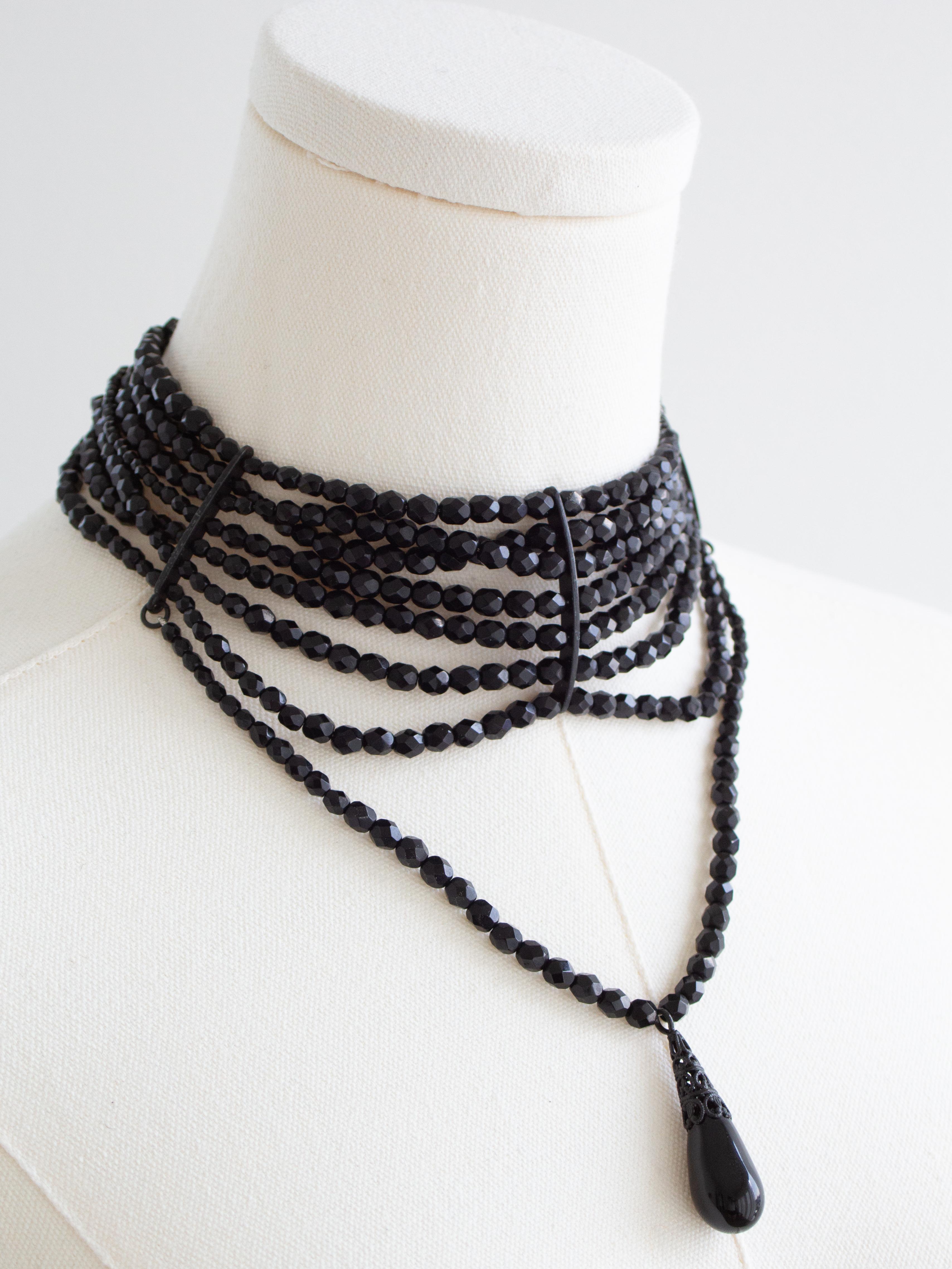 This iconic Dior “Maasai” necklace is considered one of the most collectible and desirable designs from the Galliano era. Crafted from multiple strands of faceted black beads that form a structured choker, the piece is finished with a dramatic