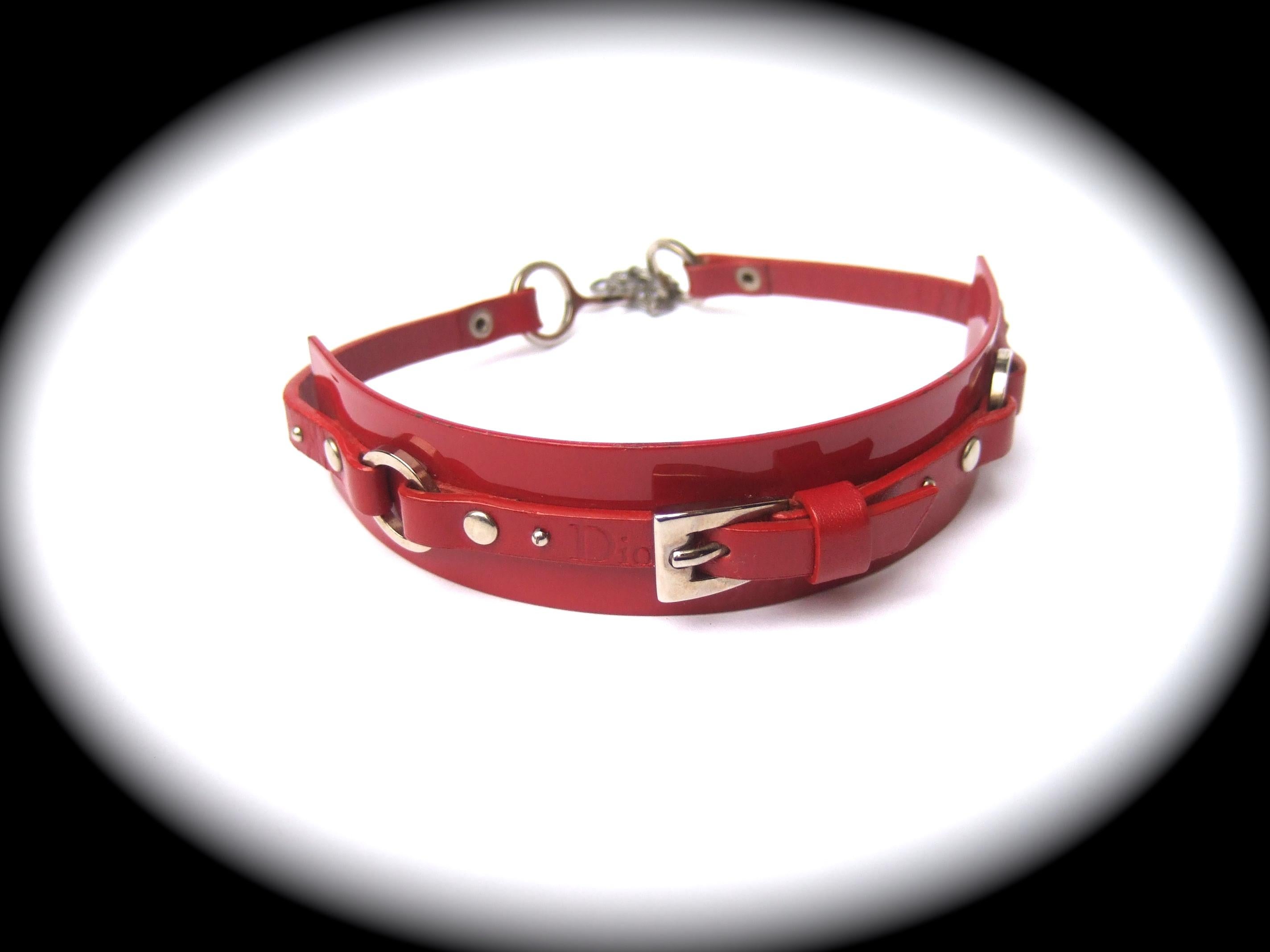 Christian Dior John Galliano Collier ras de cou en cuir rouge et métal c 2005 
Le tour de cou avant-gardiste est conçu avec une bande métallique rigide incurvée au centre du cou
Le bracelet métallique incurvé est gainé de laque émaillée rouge très
