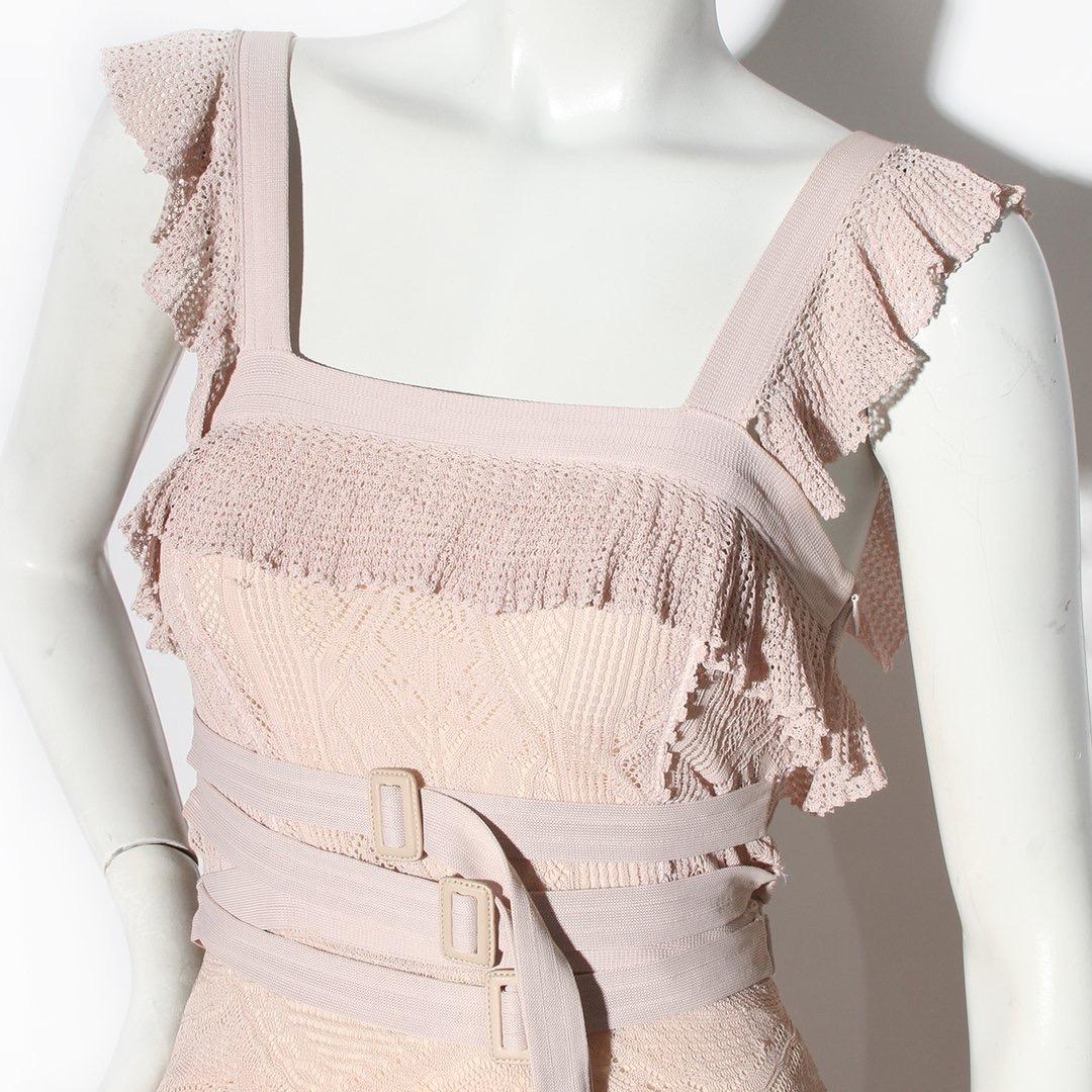 Bandage-Spitzenkleid von Christian Dior 
Ungefähr 2011
Hellrosa Spitze 
Einzelne Rüsche entlang der Büste 
Quadratischer Ausschnitt
Rüschenärmel
Verstellbarer Dreifachgürtel über der Taille 
Gerafftes Rüschendetail am Po 
Unsichtbarer Reißverschluss