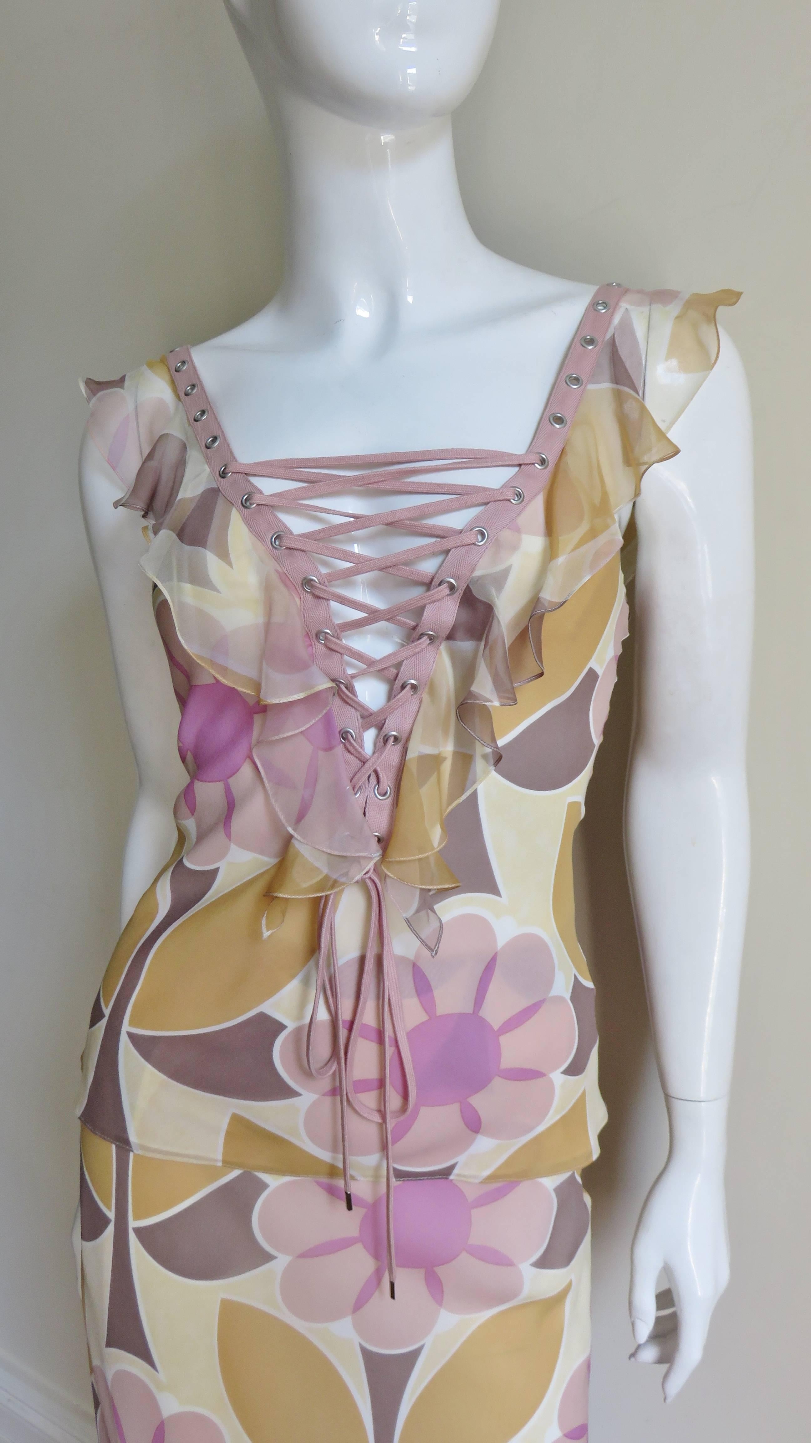 An incredible 2 piece silk skirt and top set in a pink and yellow flower print from John Galliano for Christian Dior. The top has adjustable functional pink lacing at the center front neckline and back through to the waist.  The skirt has a flirty