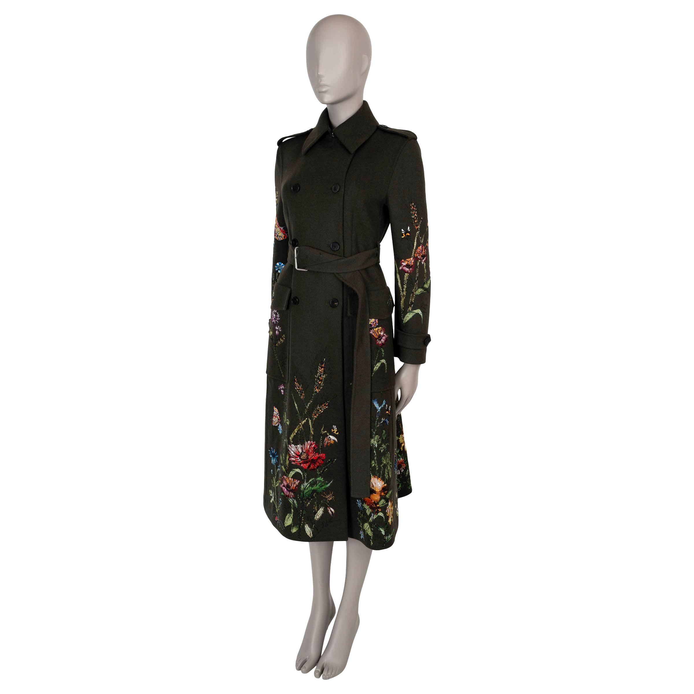 This 100% authentic Christian Dior trench coat in loden green wool-rabbit hair-blend showcases a stunning multicolor meadow-inspired embroidery, adding a whimsical touch to a classic design. Featuring epaulettes, belted cuffs, and two flap pockets,