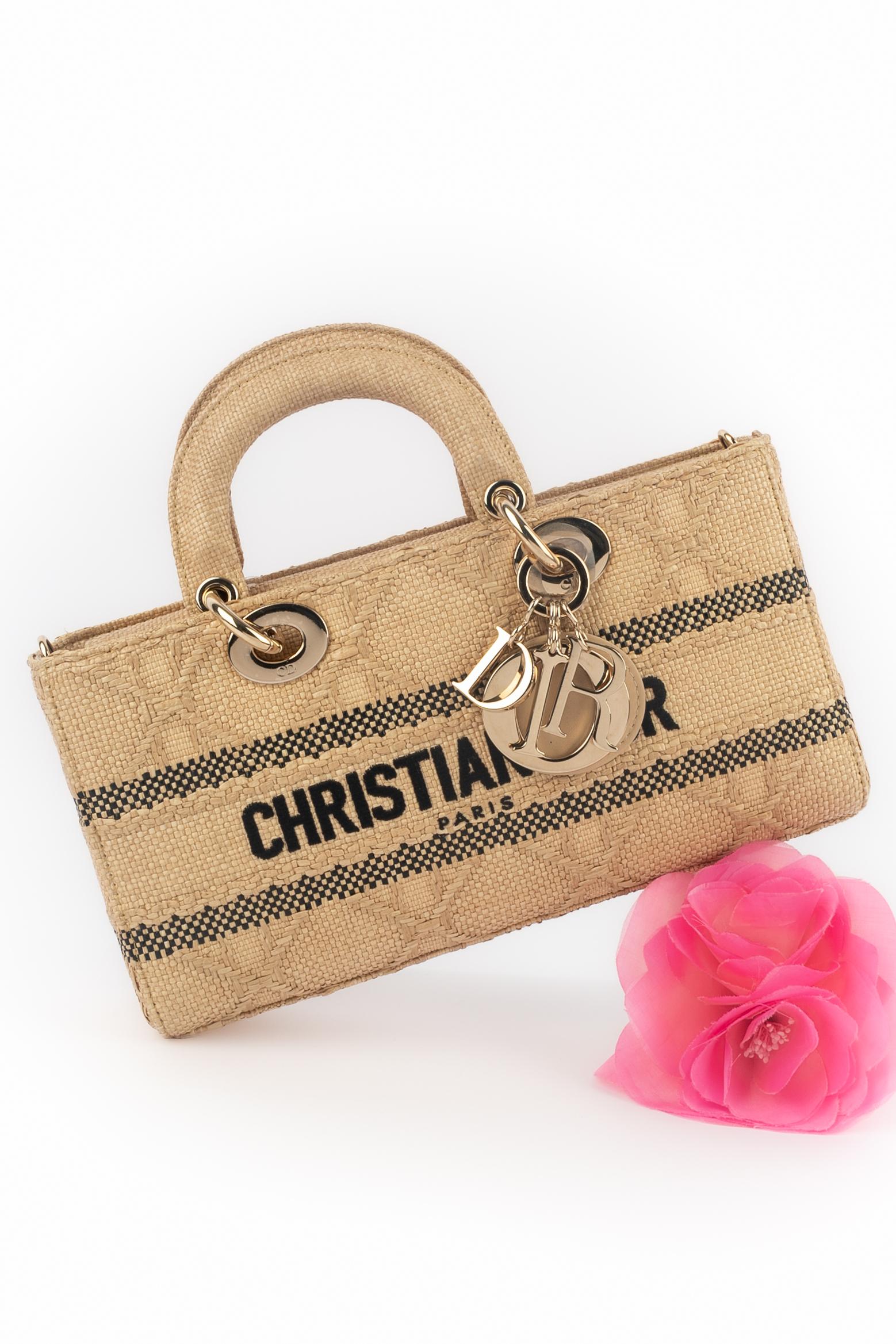 DIOR - (Fabriqué en Italie) Sac à main en raphia dans les tons beige et noir. Éléments métalliques dorés. Pièce portant un numéro de série. Une Collectional 2022 sous la direction artistique de Maria Grazia Chiuri.

Condit :
Très bon