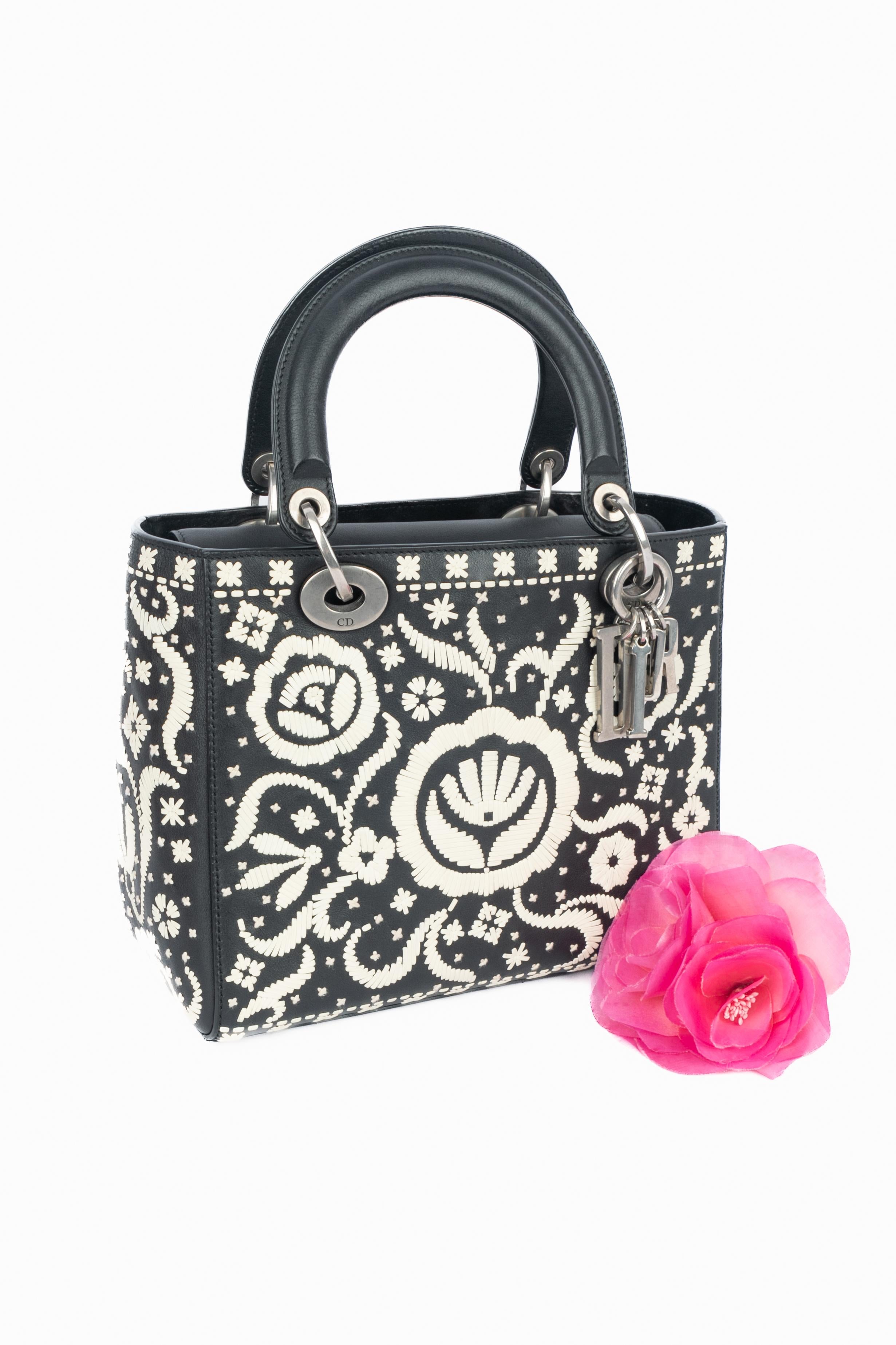 DIOR - (Fabriqué en Italie) Sac Lady Dior en cuir noir et blanc avec un motif floral et les lettres de la maison en breloques de métal argenté foncé. Bandoulière amovible pour le corps. Une Collectional 2018 sous la direction artistique de Maria