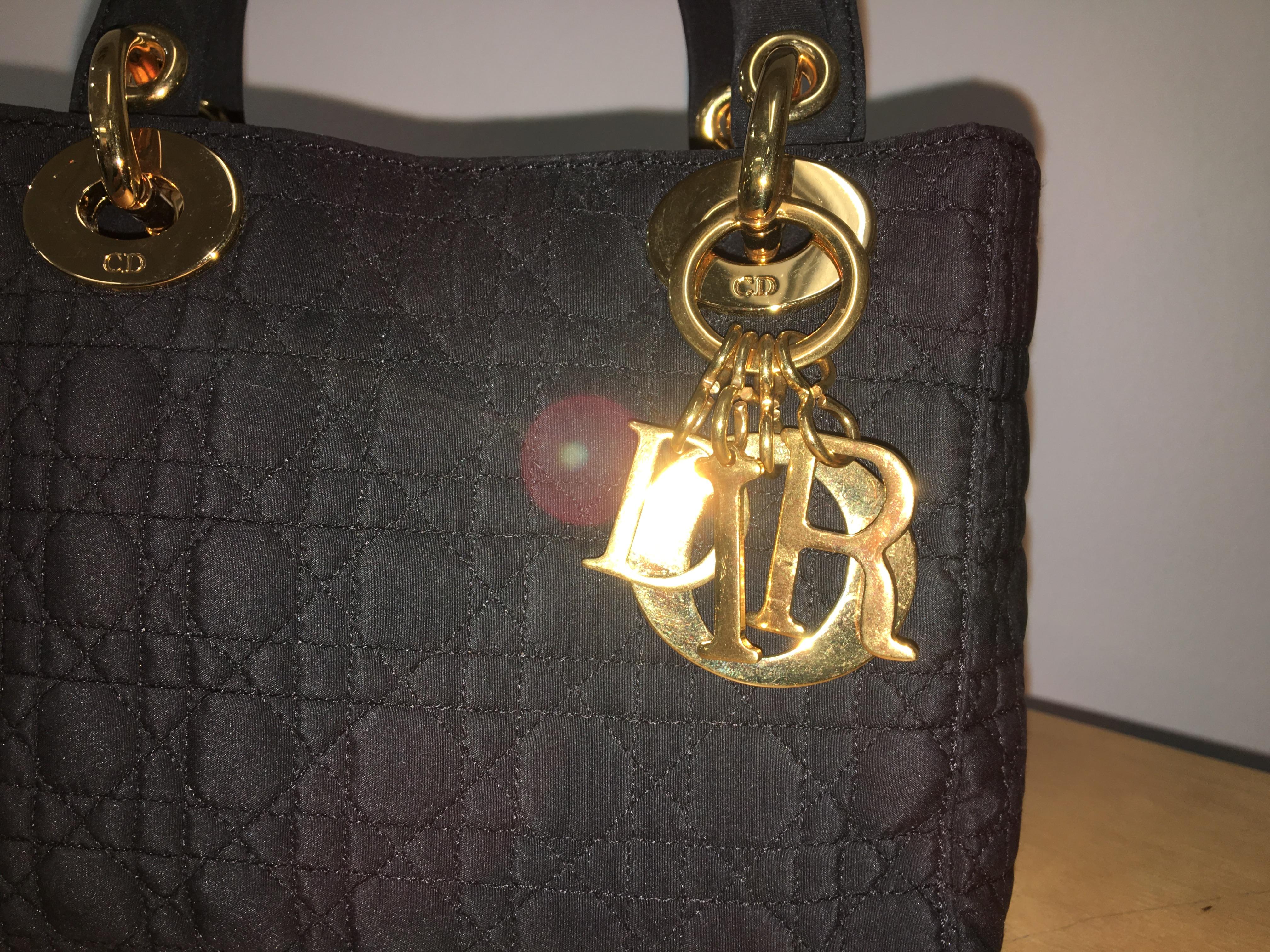 Small and elegant Lady Dior bag with gold detailing.