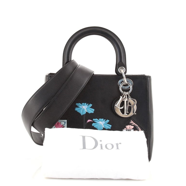 Christian Dior Lady Dior Bag Patch Embellished Leather Medium. Odor in interior. Moderate scuffs and indentations on exterior and in interior, handles and strap, creasing on front. Wear on opening corner edges, tarnish and scratches on hardware.