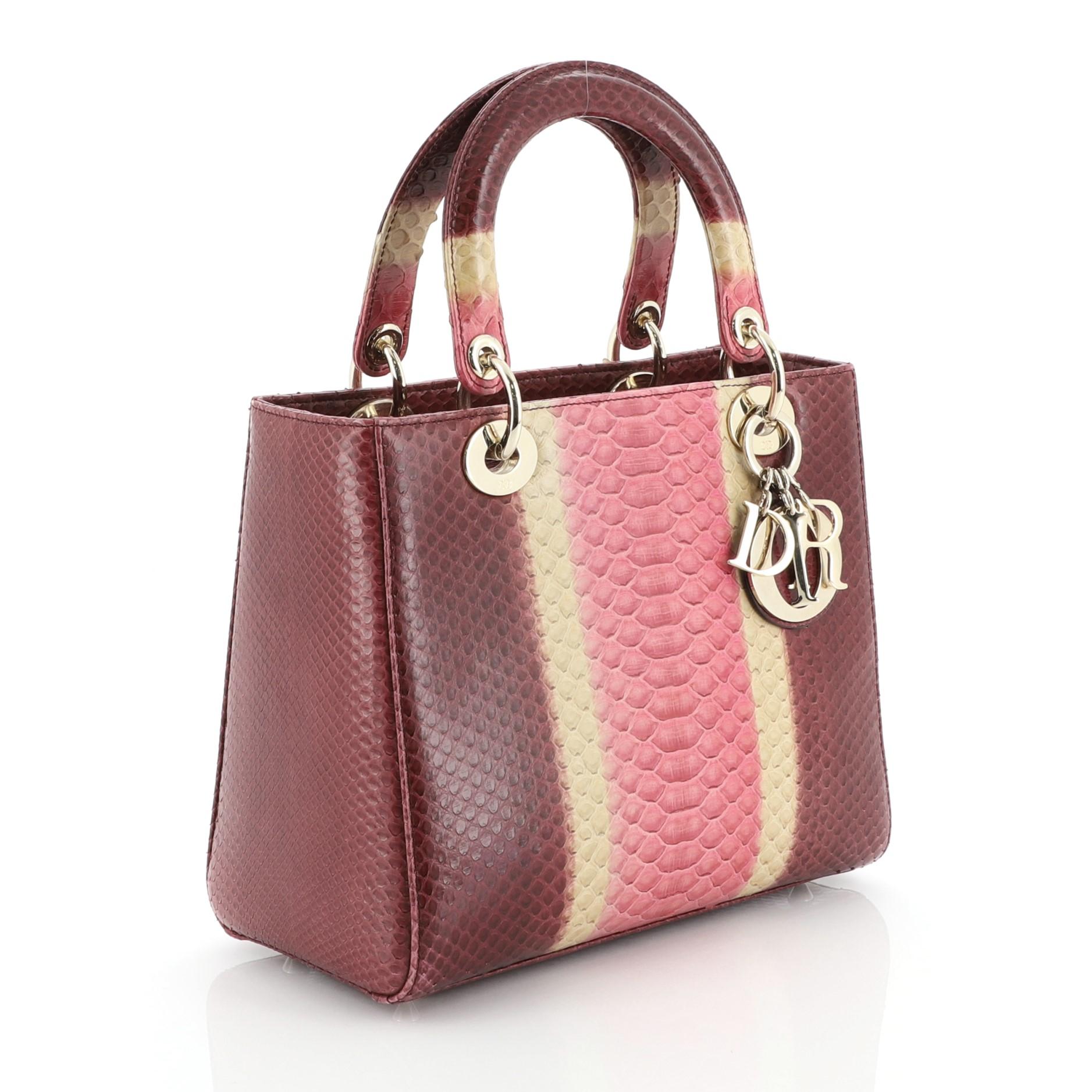 This Christian Dior Lady Dior Bag Python Medium, crafted in genuine purple multicolor python skin, features dual rolled handles with sleek Dior charms, and gold-tone hardware. Its top zipper closure opens to a purple leather interior with side zip