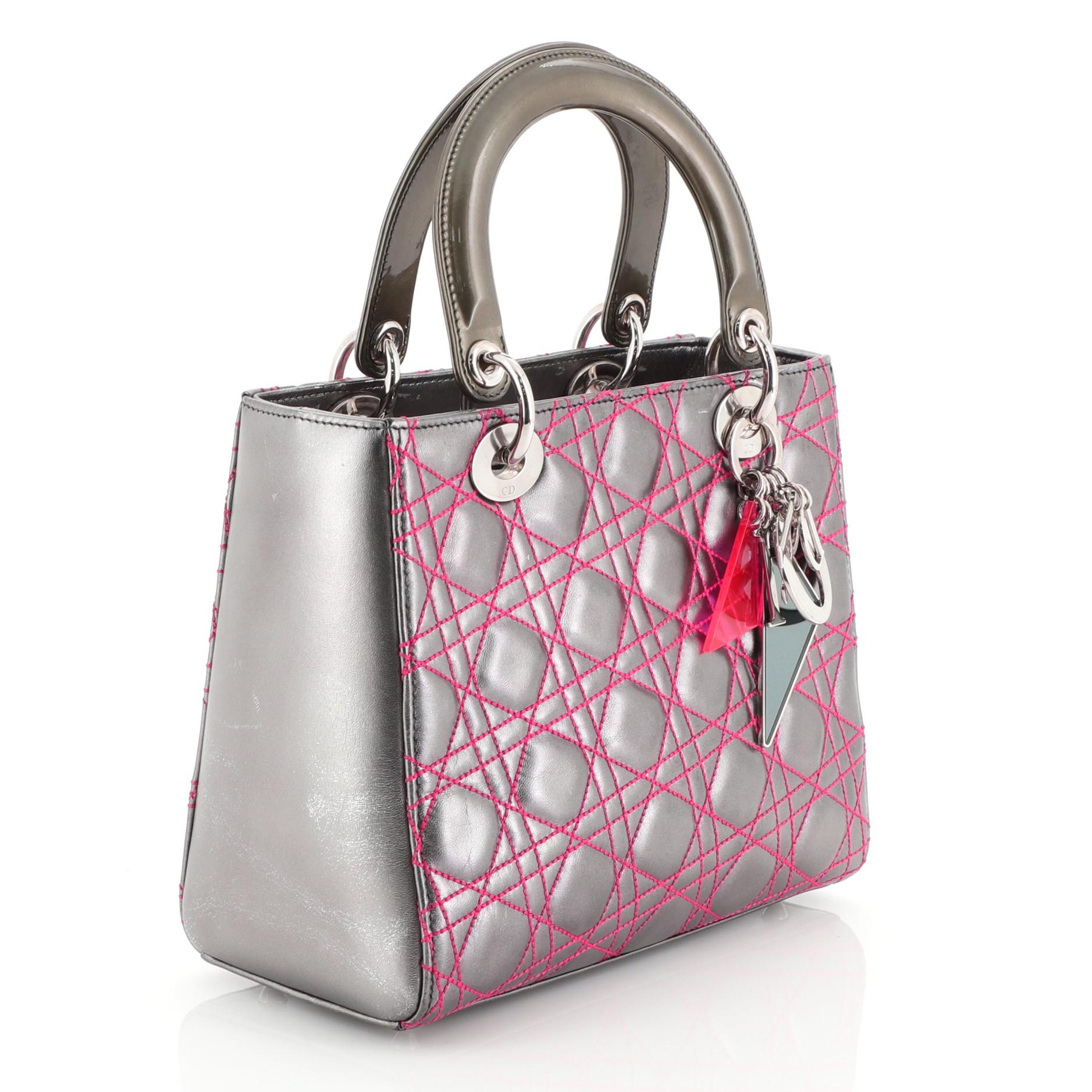 
This Christian Dior Lady Dior Handbag Anselm Reyle Cannage Quilt Leather Medium, crafted from multicolor silver cannage quilt leather, features smooth short dual handles with colorful triangular Dior charms, and silver tone hardware. Its zip lock