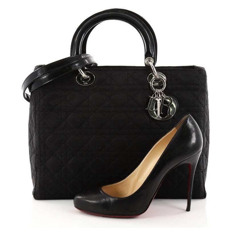 This authentic Christian Dior Lady Dior Handbag Cannage Quilt Nylon Large is a classic staple that every fashionista needs in her wardrobe. Crafted from black nylon in Dior's iconic cannage quilting, this boxy bag features dual-rolled handles with