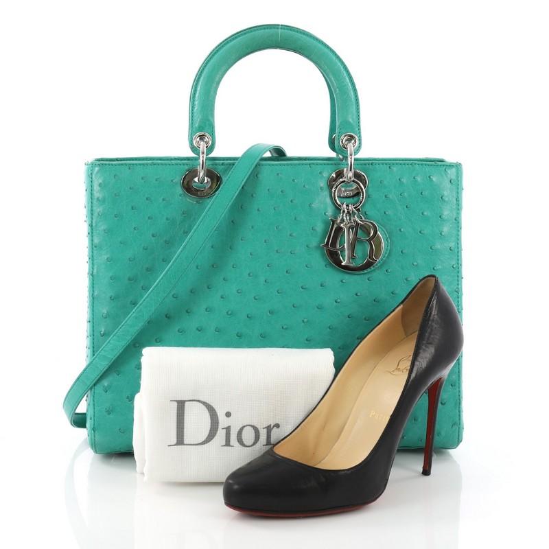 This Christian Dior Lady Dior Handbag Ostrich Large, crafted in genuine green ostrich skin, features dual top leather handles, Dior charms, and silver-tone hardware. Its zip closure opens to a green leather interior with side zip pocket. **Note: