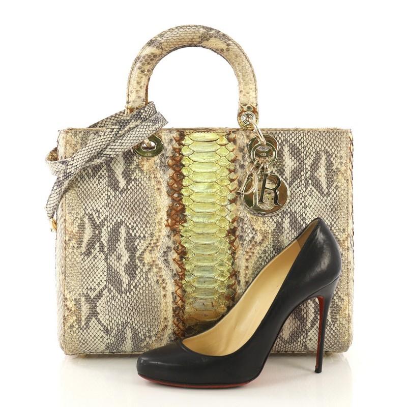This Christian Dior Lady Dior Handbag Python Large, crafted in genuine gold python skin, features dual top leather handles, Dior charms, and gold-tone hardware. Its zip closure opens to an off-white leather interior with side zip pocket. **Note: