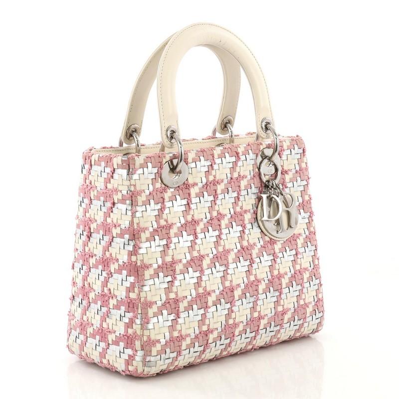 This Christian Dior Lady Dior Handbag Woven Leather with Tweed Medium, crafted in pink woven leather with tweed, features dual top leather handles, Dior charms, and silver-tone hardware. Its zip closure opens to a pink leather interior with side zip