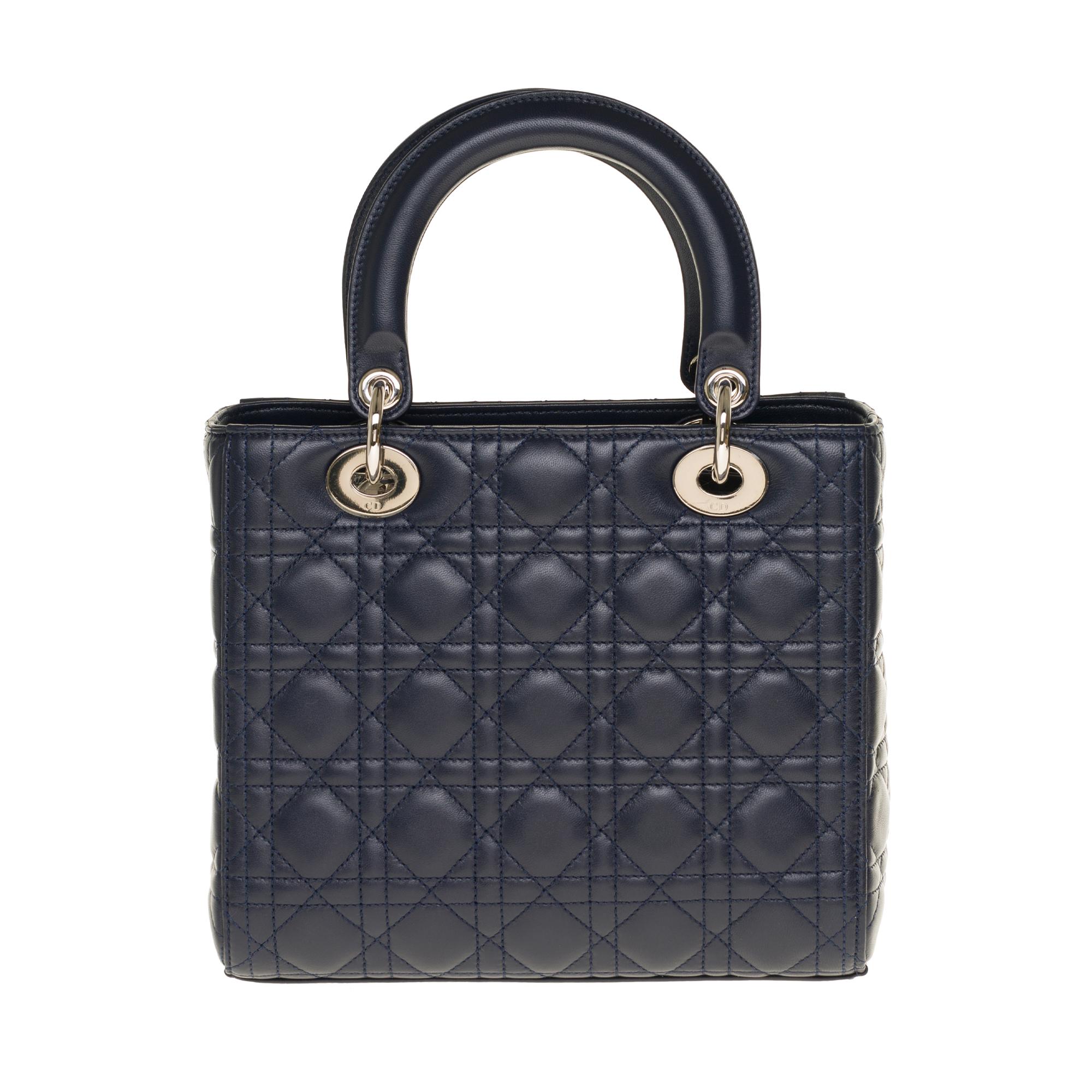 The very Classy shoulder bag Dior Lady Dior medium model in blue navy cannage leather, silver metal trim, double handle in blue leather, removable shoulder strap handle in blue leather allowing a hand or shoulder support or shoulder strap.

It’s a