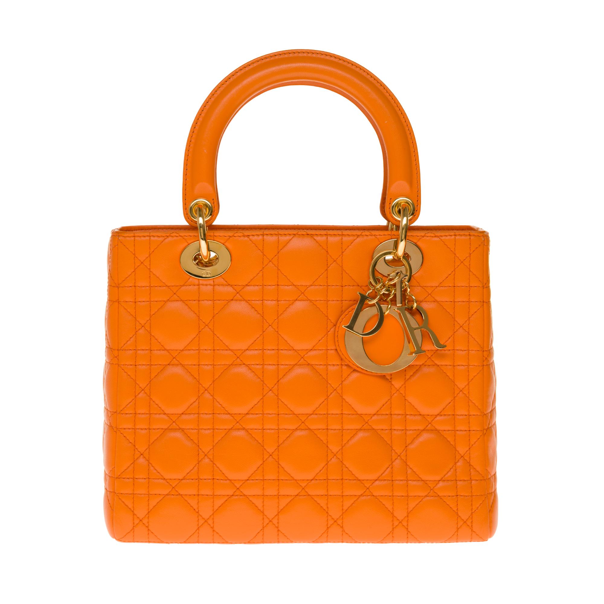Very chic shoulder bag Dior Lady Dior medium model in leather cannage color pumpkin, gold metal hardware, double handle in orange leather, handle removable shoulder strap in orange leather allowing a hand or shoulder or shoulder strap.

It’s a zip