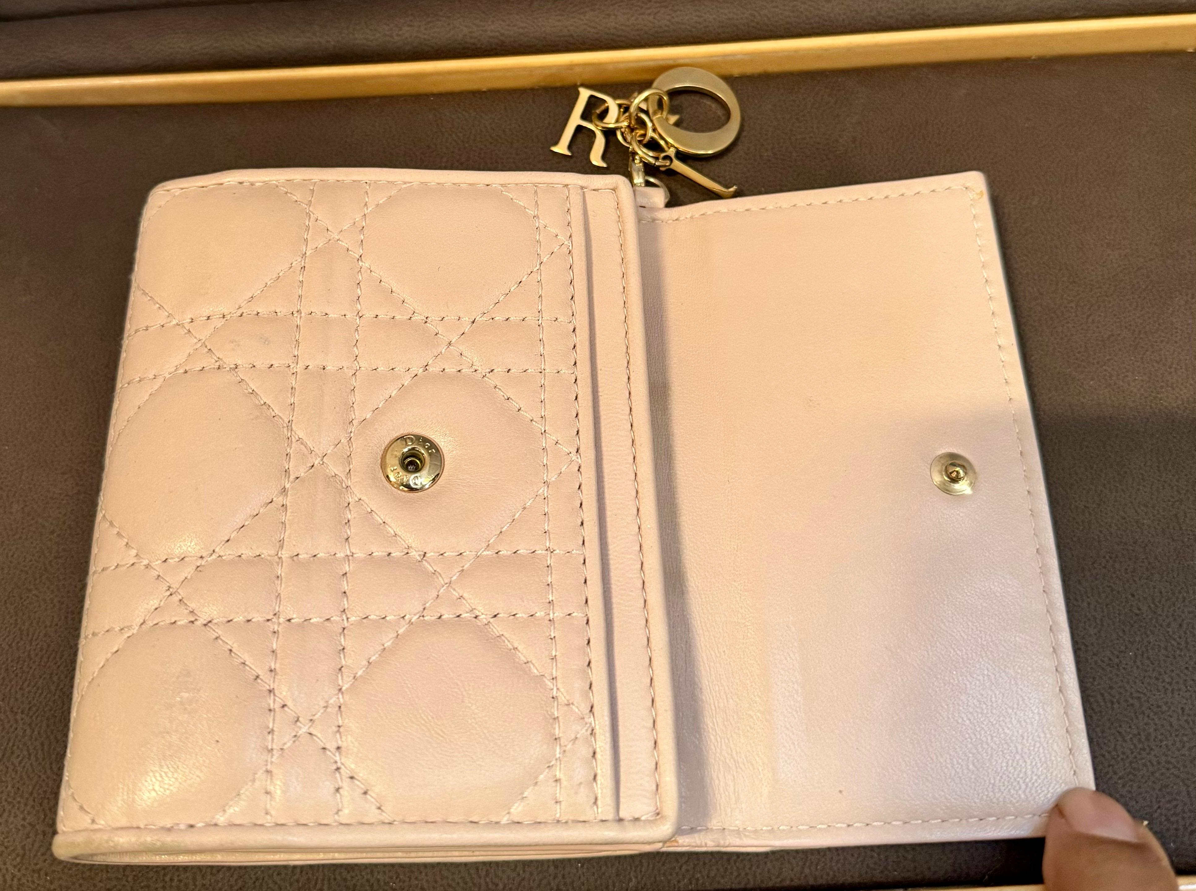 DIOR Lady Dior Mini Wallet

AUTHENTIC LADY DIOR MINI WALLET in beige colored lambskin with Cannage stitching.

This beautiful wallet while mini is spacious. It includes a detachable DIOR charm, 8 card slots, 1 bill holder, 1 patch pocket, 1 coin