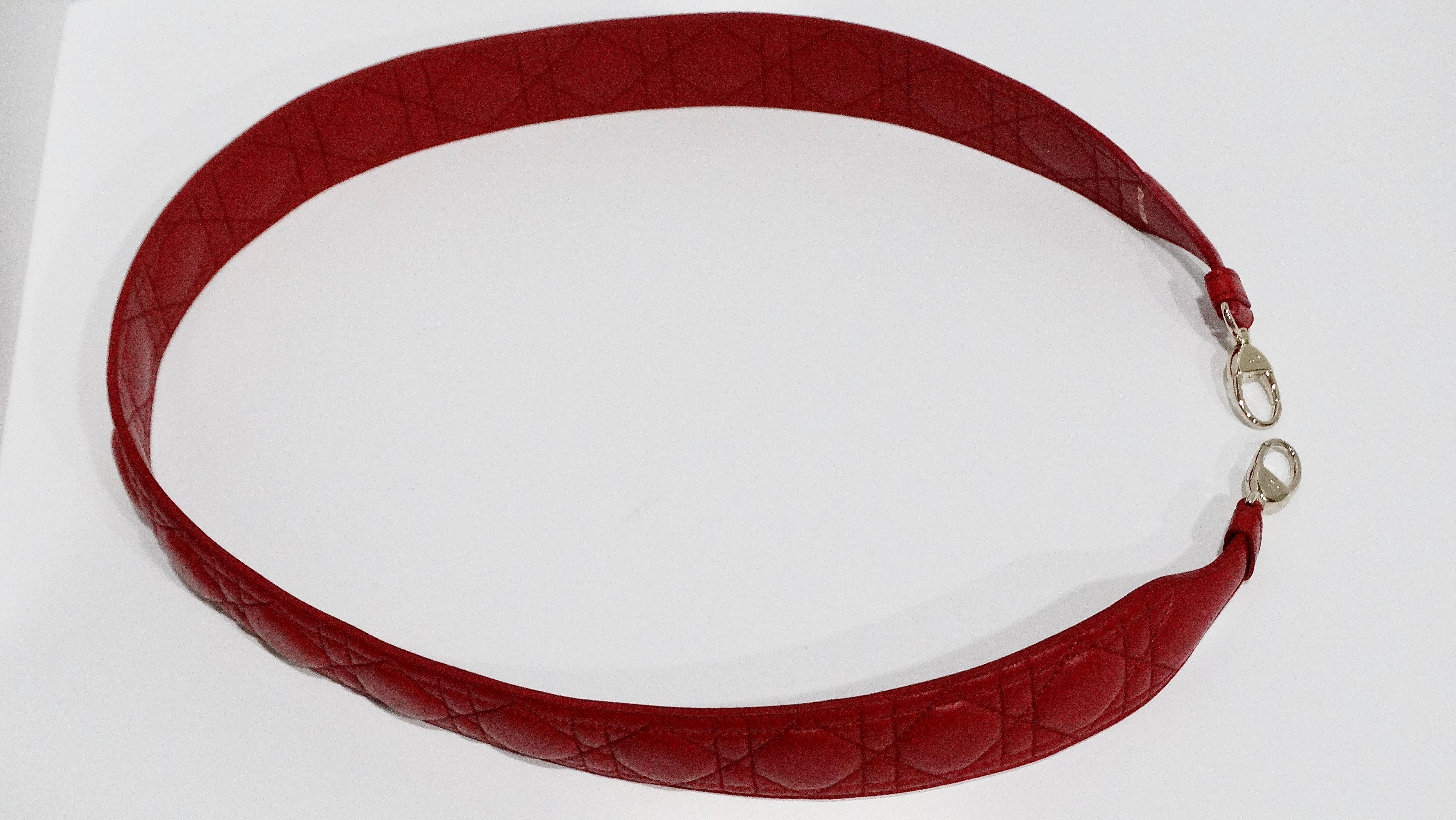 The red leather Christian Dior Lady Dior bag strap is a luxurious and versatile accessory that can elevate any handbag. Crafted from sumptuous red lambskin leather, it features the iconic Cannage design, which adds a touch of elegance and