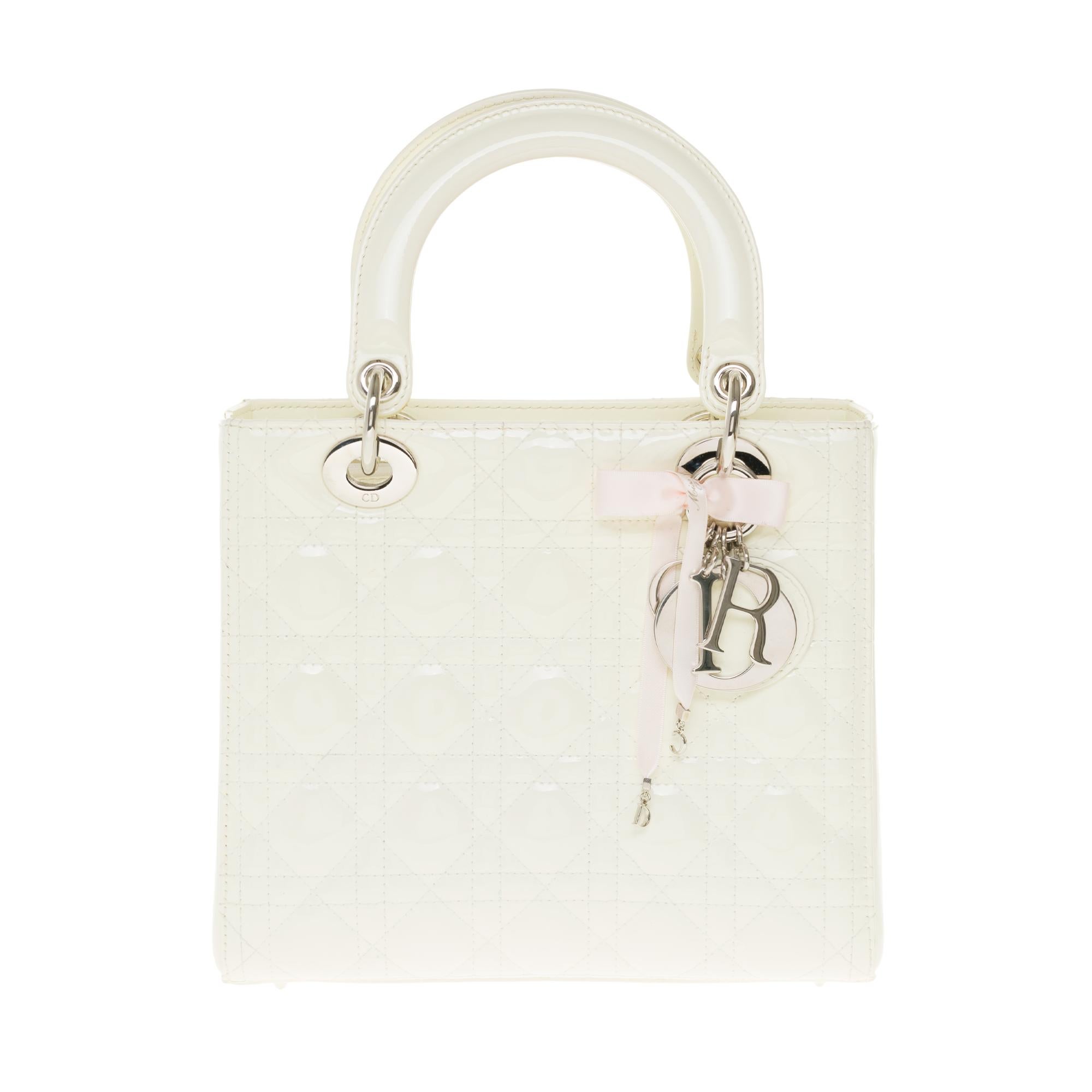 The Lady Dior bag perfectly embodies the vision of elegance and beauty of the House of Dior. Refined and feminine, it is a timeless creation and yet always current.
Crafted from white patent calfskin with Cannage stitching, its legendary quilted
