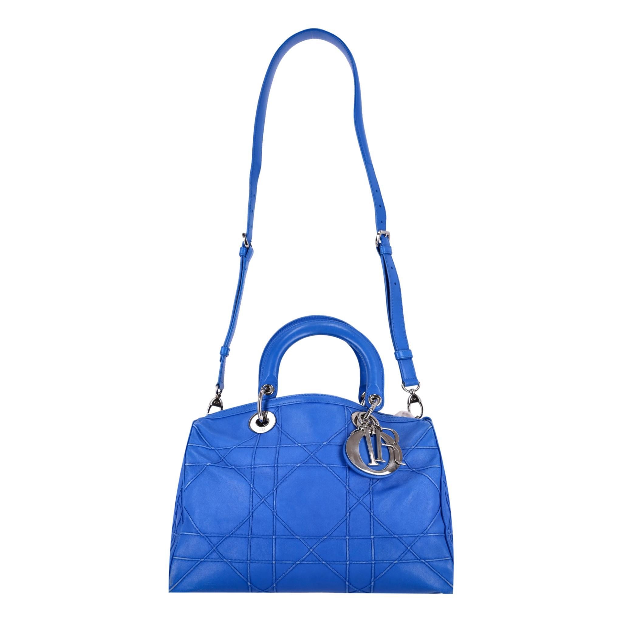 Christian Dior Lambskin Leather Cannage Granville Polochon Bag

Blue tote bag crafted of geometric stitched lambskin leather with silver hardware and signature D.I.O.R. charms.

Featuring dual, rolled top handle and detachable, adjustable leather