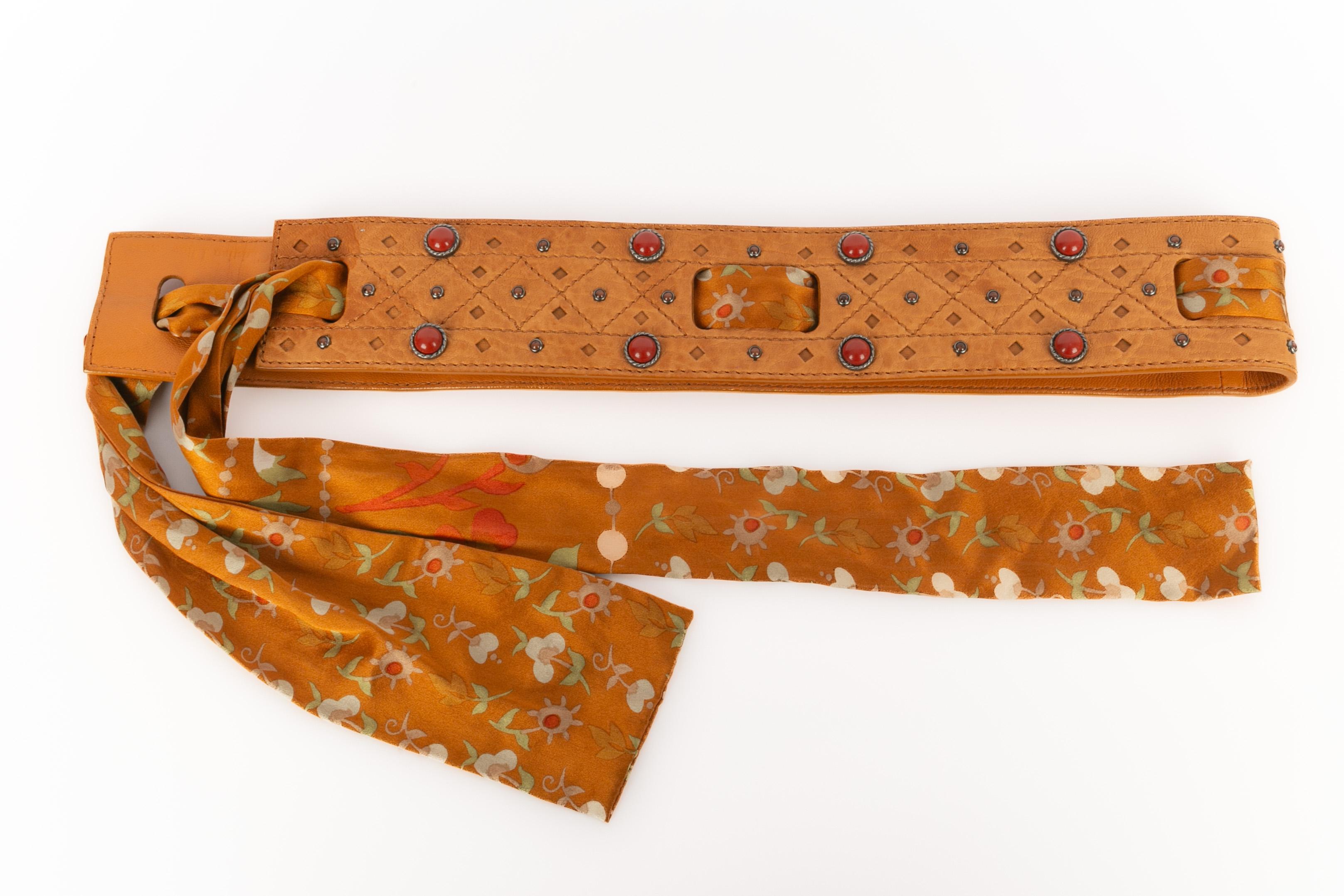 DIOR - (Made in Italy) Durchbrochener, orange-brauner Ledergürtel, verziert mit silbernem Metall und roten Harz-Cabochons. Leder, verflochten mit einem Seidenband mit Blumenmuster.

Bedingung:
Sehr guter Zustand

Abmessungen:
Länge: 150