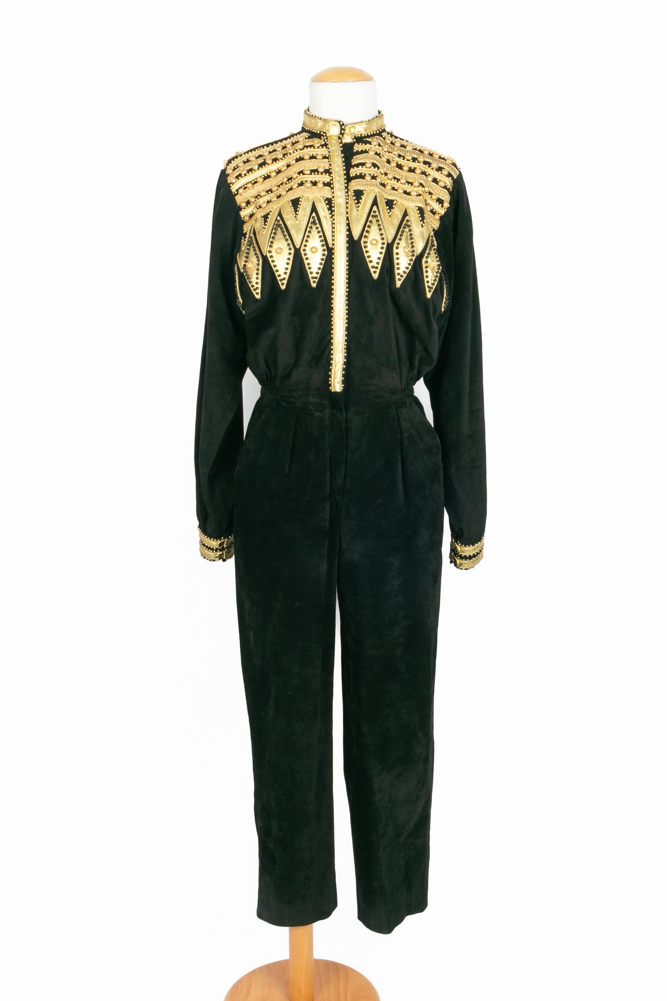 DIOR - (Made in France) Schwarzer Jumpsuit aus Samt mit goldenen Lederbortenapplikationen, die mit Goldfäden, schwarzen Perlen und Metallic-Perlen bestickt sind. Zusammensetzung und Größe Etiketten fehlen, es passt ein 36FR.

Bedingung:
Sehr guter