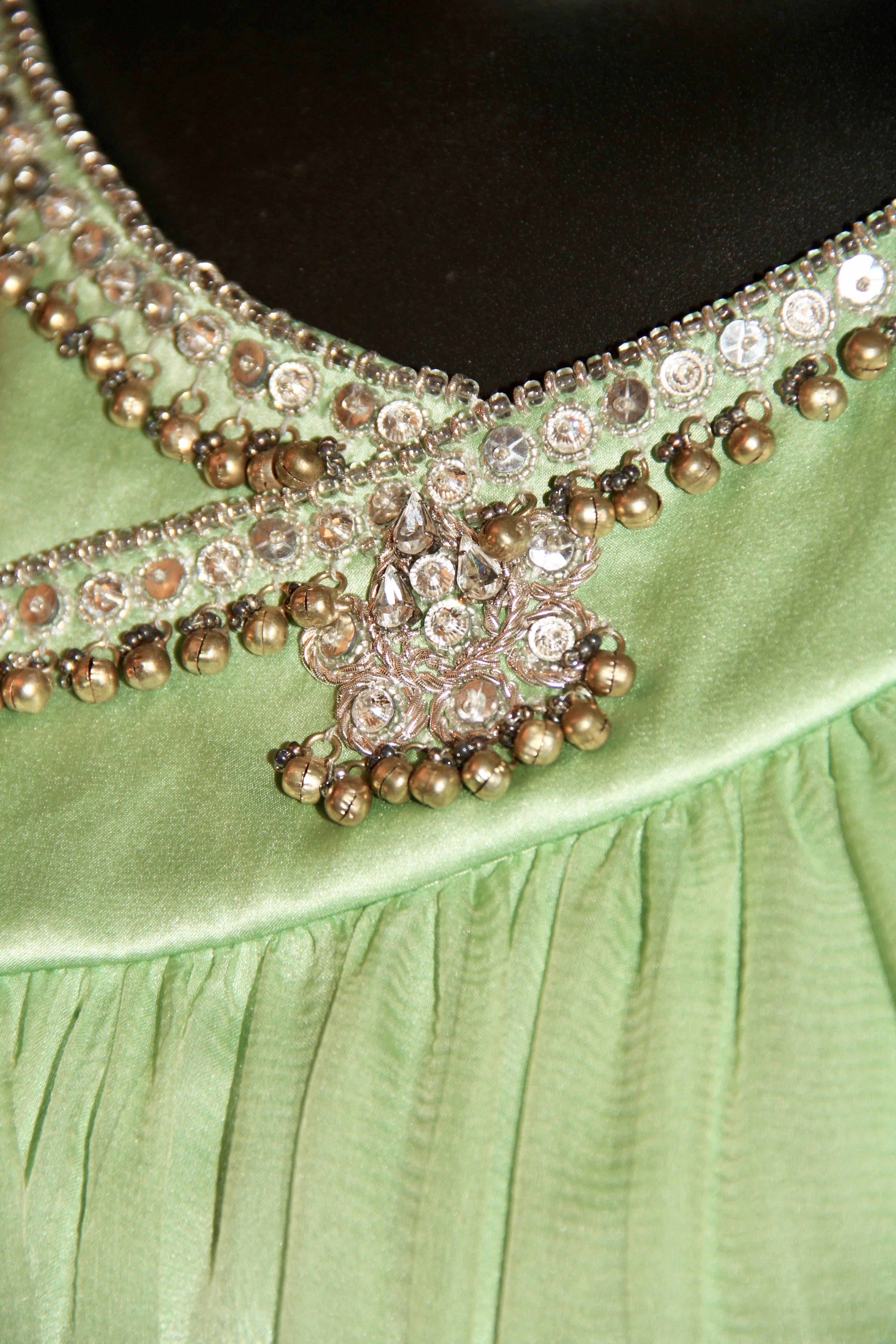 With a bit of Grecian influence, John Galliano for Christian Dior recreated the draping style in an outstanding way. This flimsy light green long dress features beads, pearls and rhinestones sewn throughout the collar. 
Fabric: Satin and silk